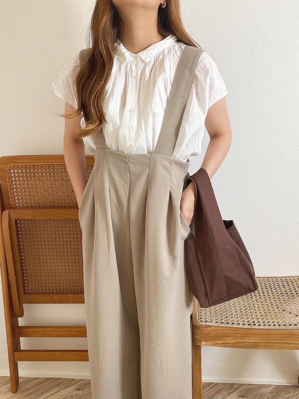ベージュ系のオールインワン・サロペット、ブラウン系のトートバッグ、ホワイト系のシャツ/ブラウスを着用したレディースの夏コーディネートの2枚目の写真