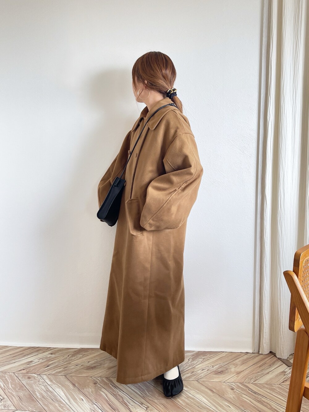 ブラウン系のステンカラーコートを着用したレディースの冬コーディネートの2枚目の写真