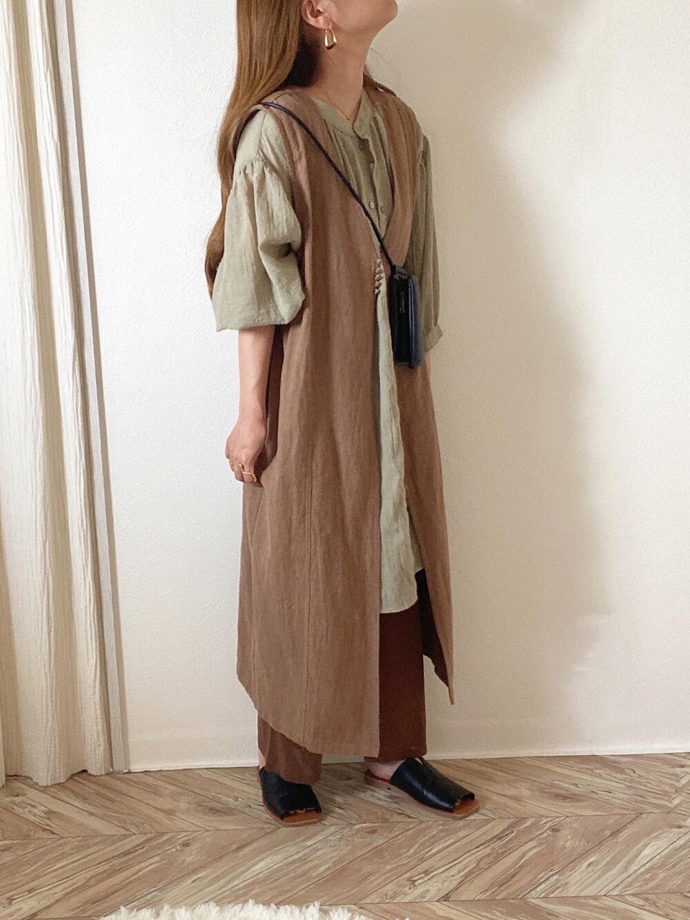 グリーン系のシャツ/ブラウス、ブラウン系のベスト、ブラック系のショルダーバッグを着用したレディースの夏コーディネートの2枚目の写真