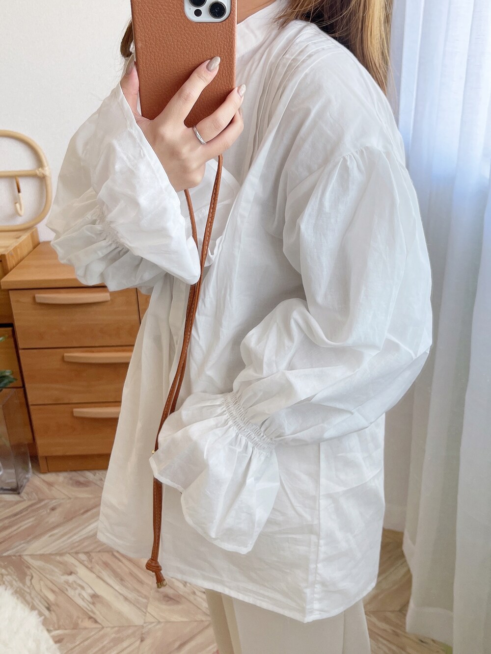 ベージュ系のニット/セーター、ホワイト系のシャツ/ブラウス、ブラック系のトートバッグを着用したレディースの冬コーディネートの3枚目の写真