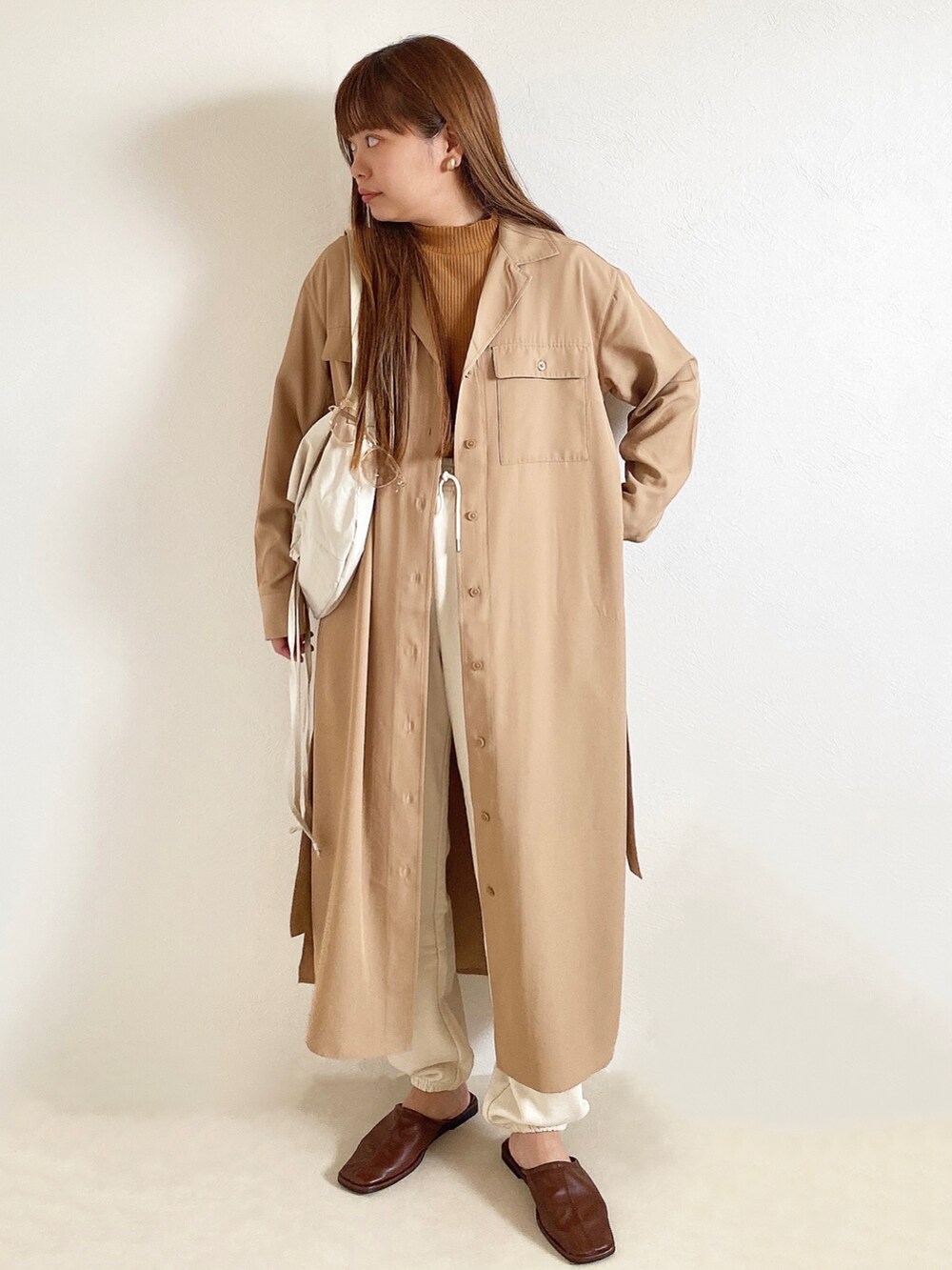 イエロー系のトップス、ベージュ系のワンピース/ドレス、ホワイト系のスウェットパンツを着用したレディースの春コーディネートの2枚目の写真