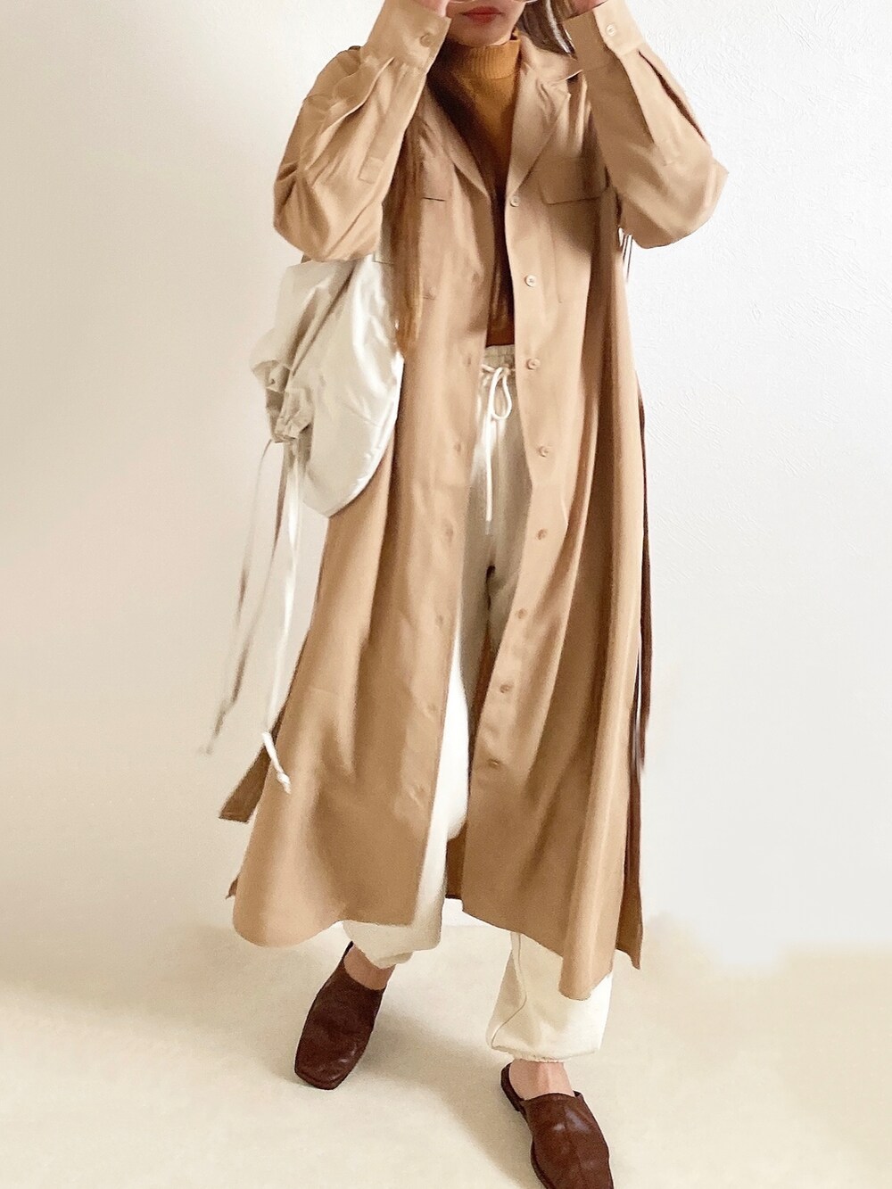 イエロー系のトップス、ベージュ系のワンピース/ドレス、ホワイト系のスウェットパンツを着用したレディースの春コーディネートの4枚目の写真