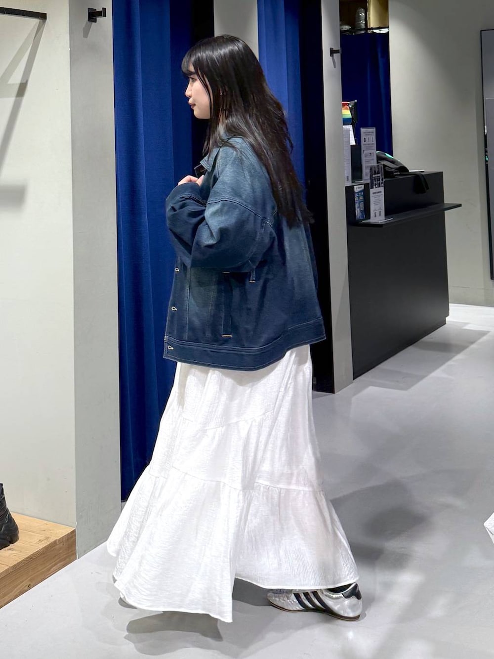 ブラック系のスウェット、ブラウン系のボストンバッグ、ブルー系のブルゾンを着用したレディースの春コーディネートの5枚目の写真