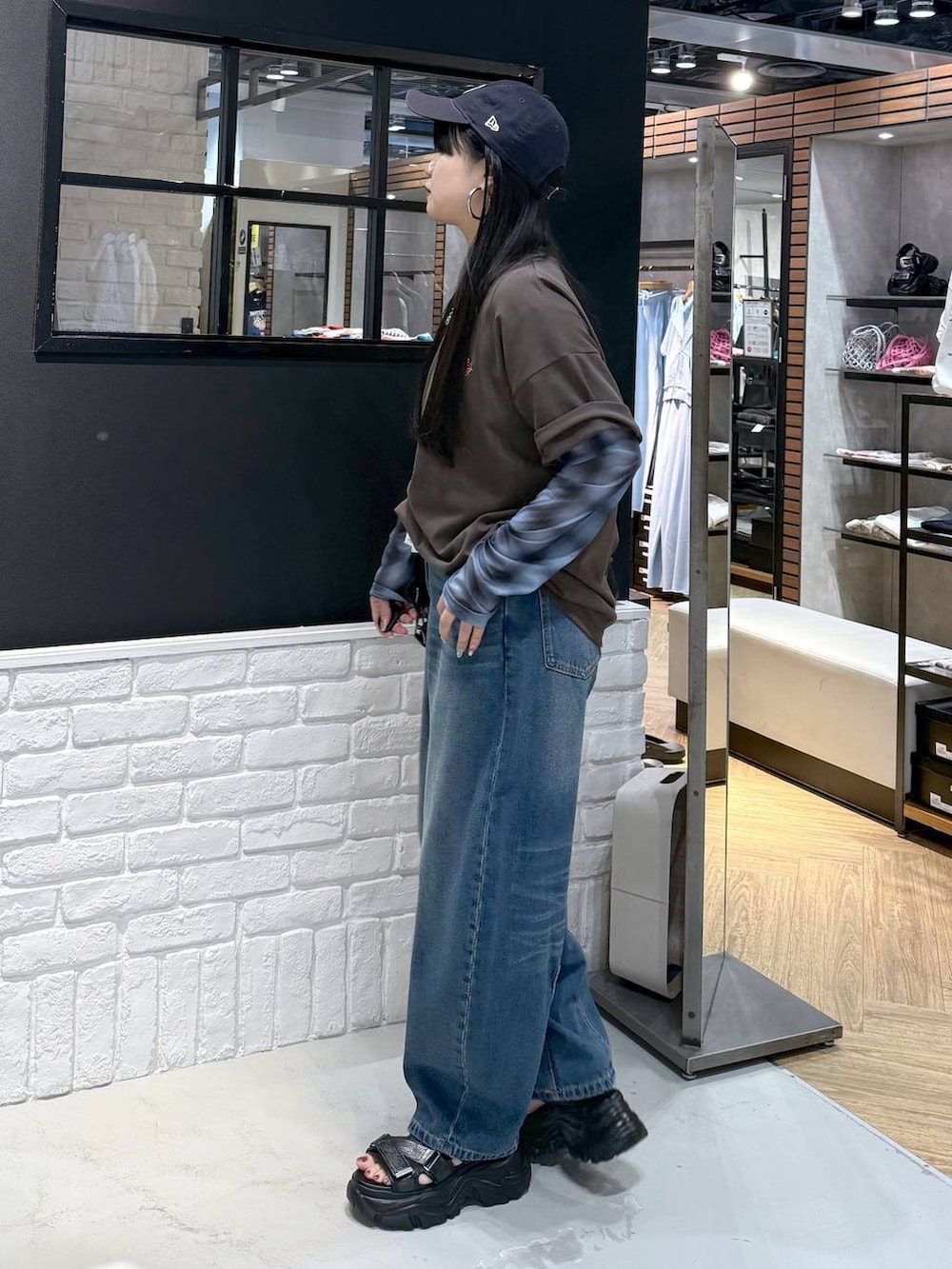 ブラウン系のショルダーバッグ、ブラック系のサンダル、ブラウン系のTシャツ/カットソーを着用したレディースの夏コーディネートの3枚目の写真