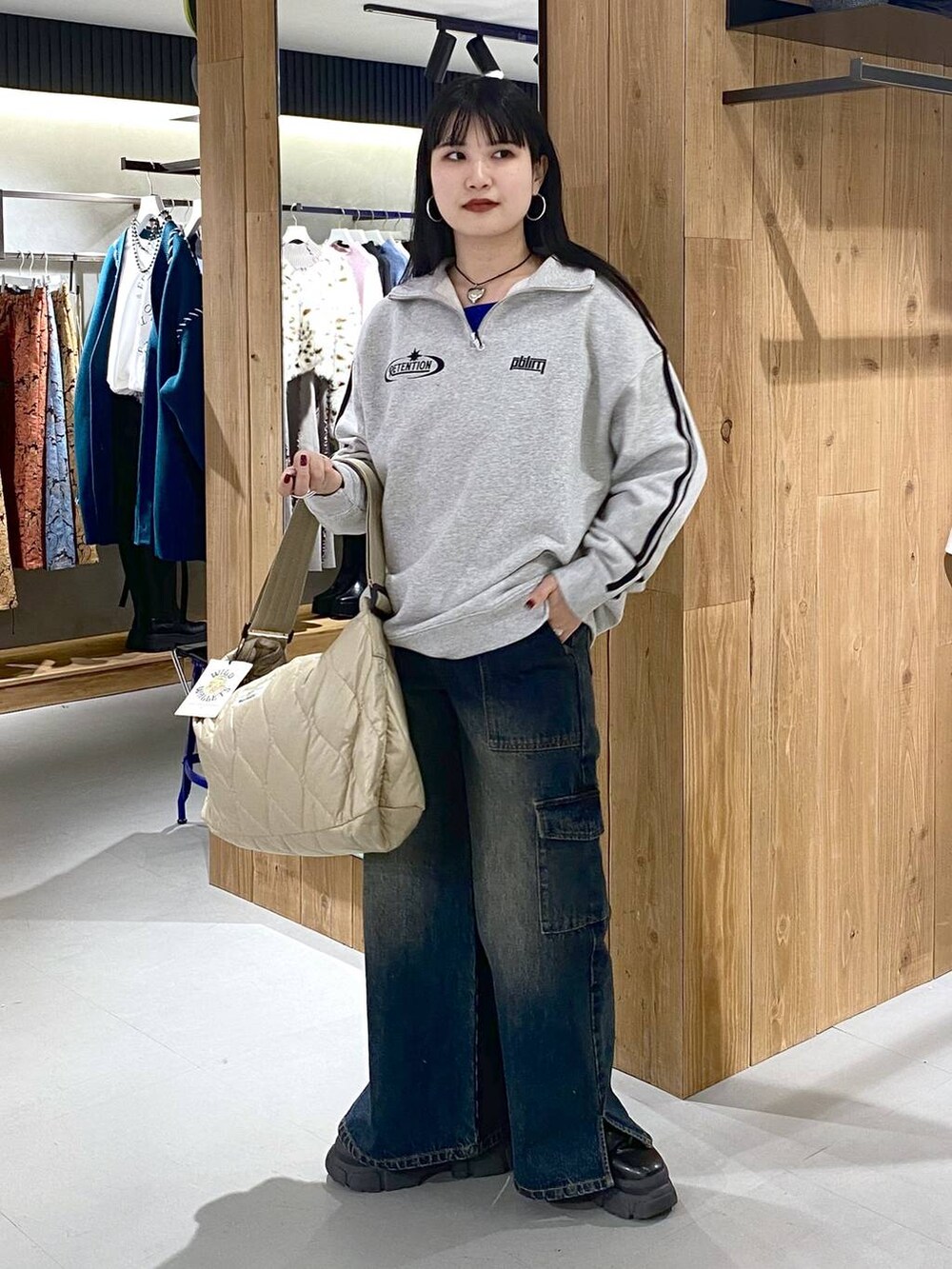 ブラック系のブーツ、グレー系のスウェット、ベージュ系のショルダーバッグを着用したレディースの冬コーディネートの3枚目の写真