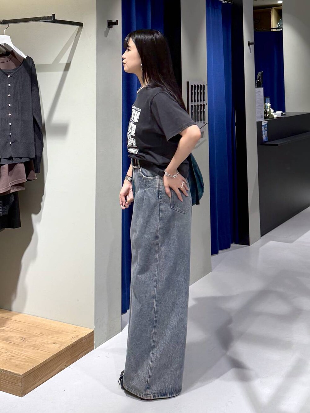 ブルー系のデニムパンツ、グリーン系のショルダーバッグ、ブラック系のパンプスを着用したレディースの秋コーディネートの2枚目の写真