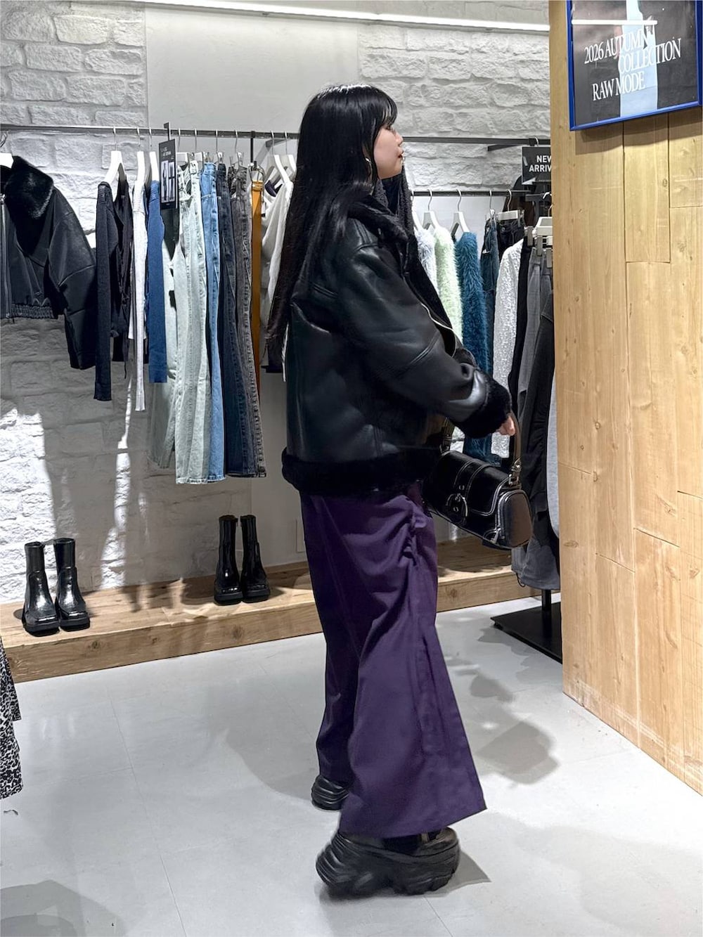 ブラック系のライダースジャケット、パープル系のその他パンツ、ブラック系のショルダーバッグを着用したレディースの秋コーディネートの6枚目の写真