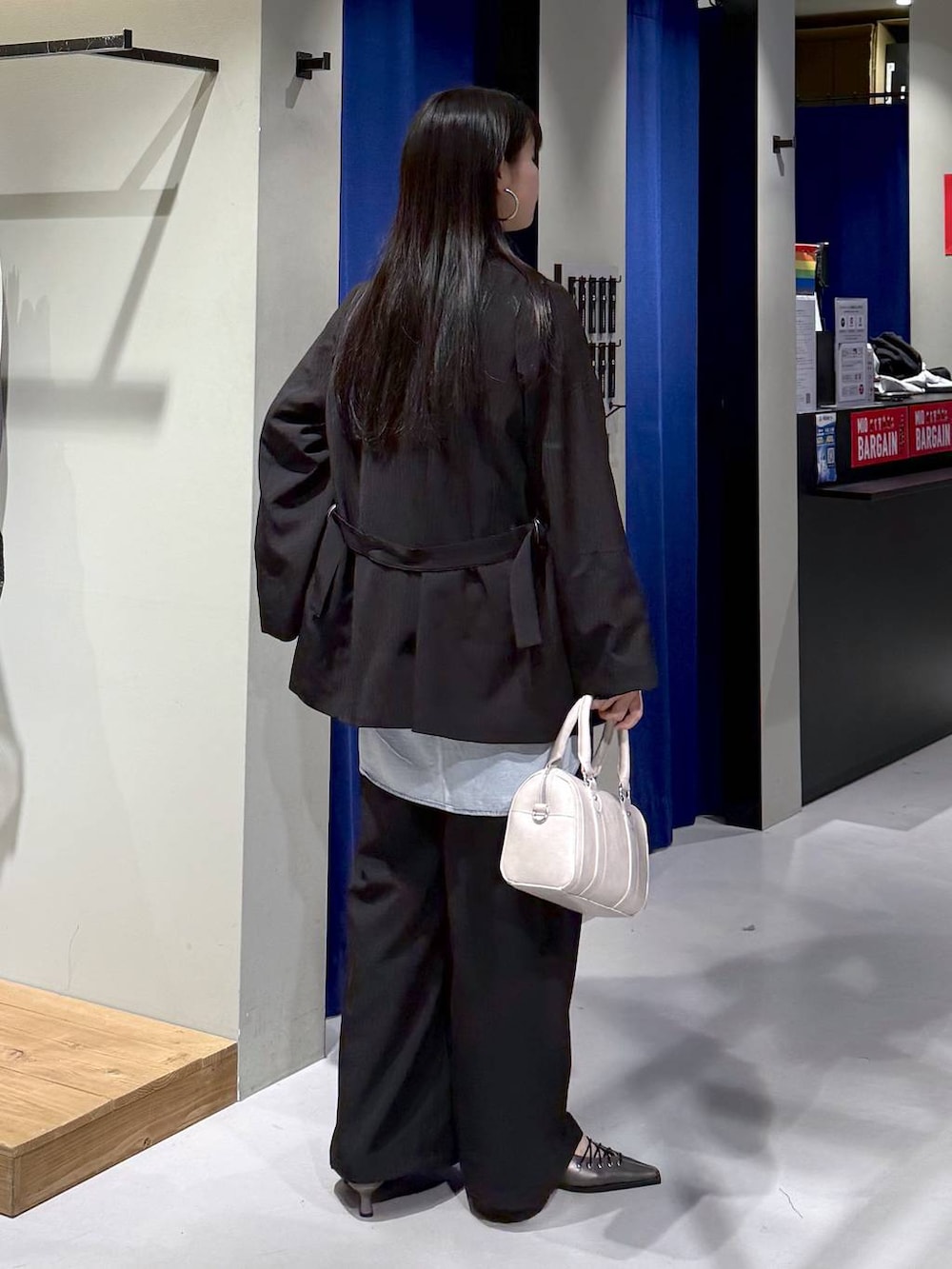 ブラック系のTシャツ/カットソー、ブラック系のテーラードジャケット、ブラック系のデニムパンツを着用したレディースの冬コーディネートの7枚目の写真