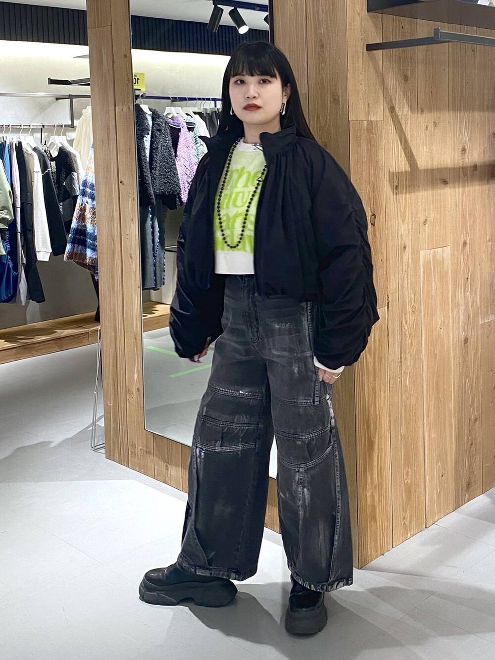 ブラック系のブーツ、ホワイト系のニット/セーター、ブラック系のショルダーバッグを着用したレディースの冬コーディネートの7枚目の写真