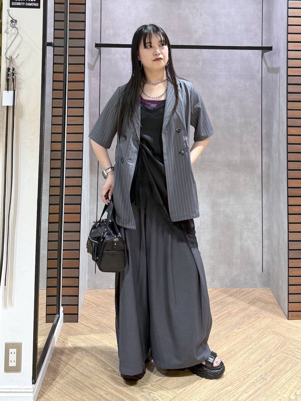 ブラック系のデニムパンツ、ブラック系のショルダーバッグ、ブラック系のチュニックを着用したレディースの夏コーディネートの7枚目の写真