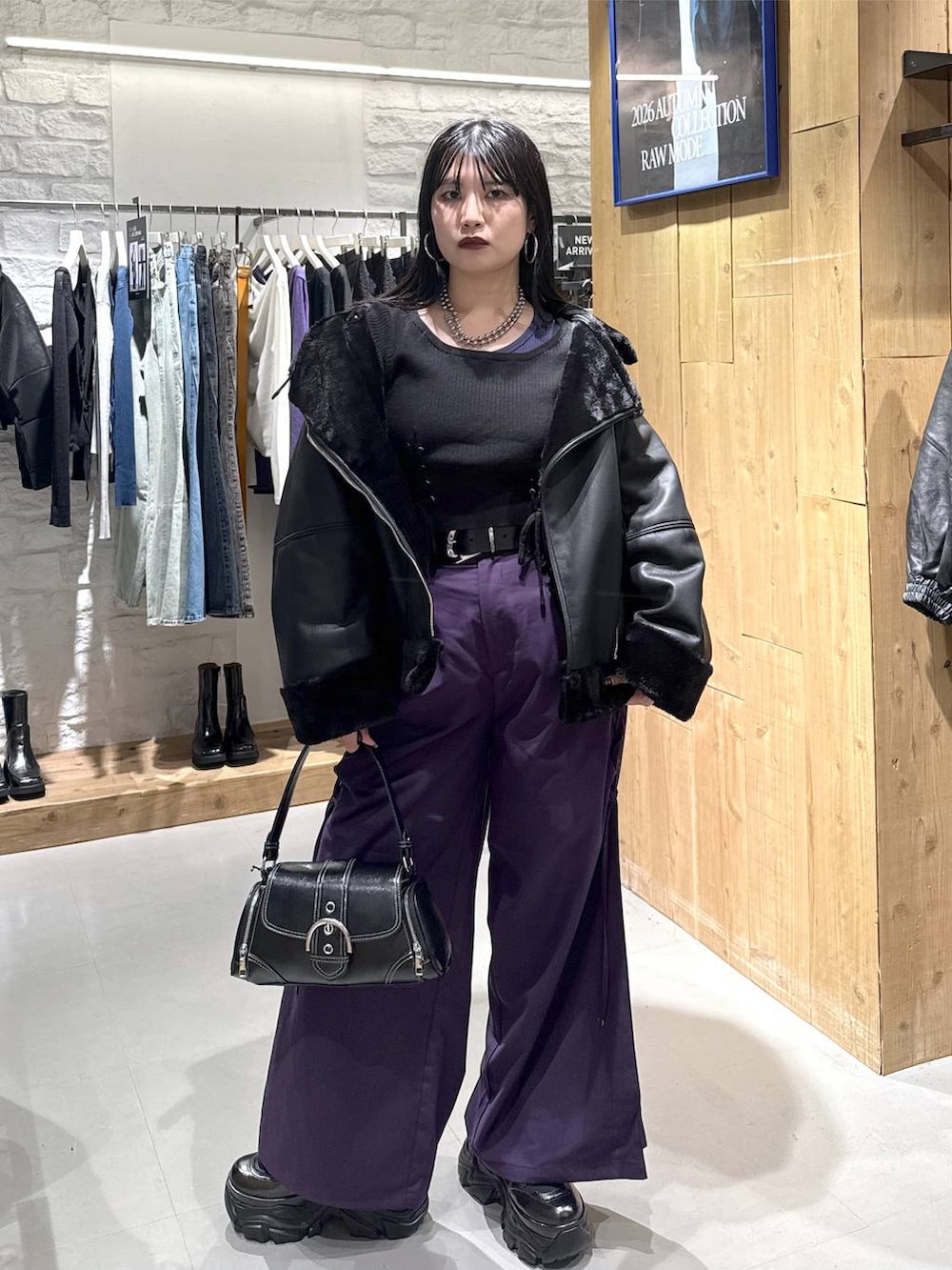ブラック系のライダースジャケット、パープル系のその他パンツ、ブラック系のショルダーバッグを着用したレディースの秋コーディネートの7枚目の写真