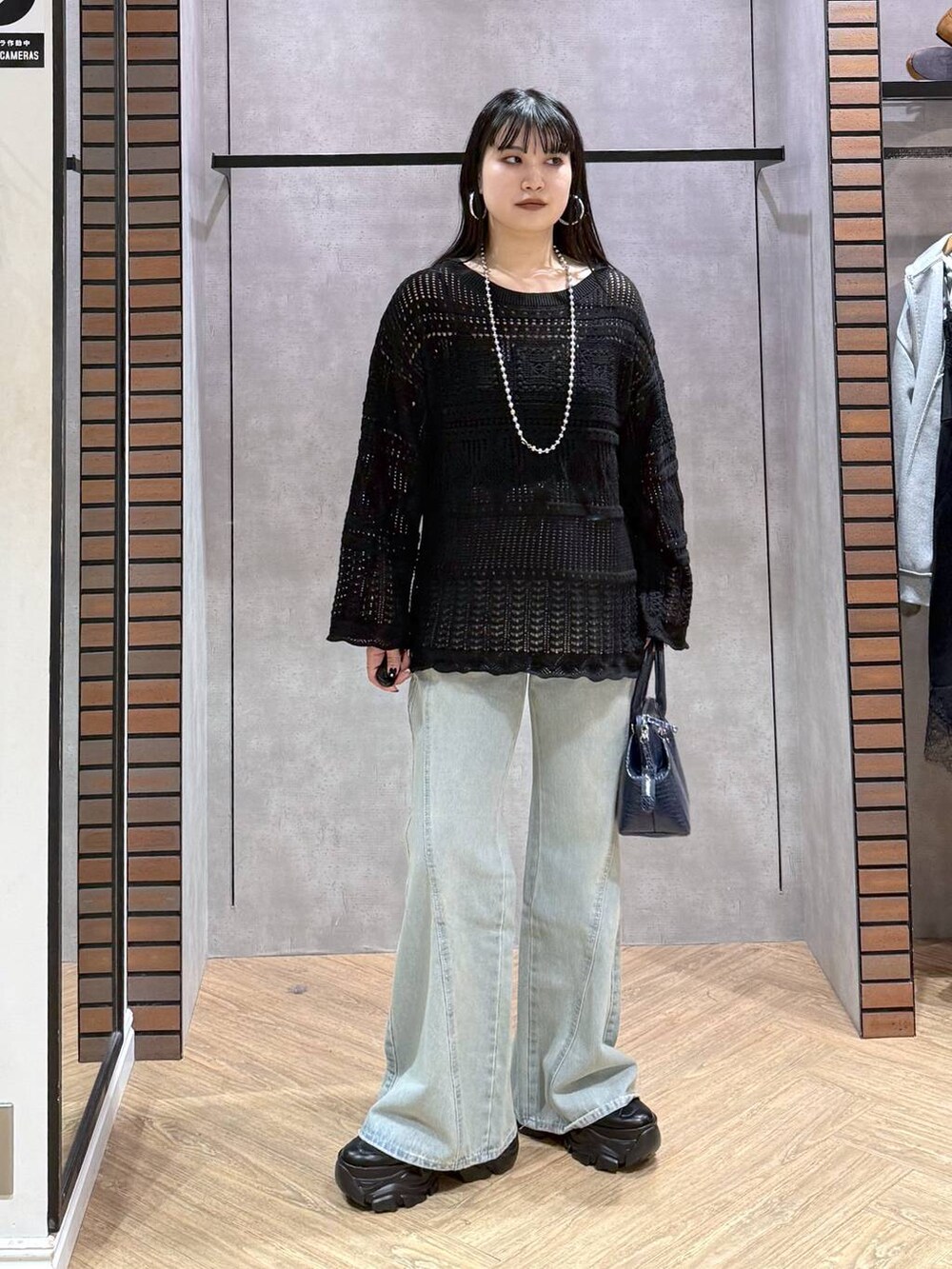 ブラック系のスニーカー、ブラック系のキャミソール、ブルー系のデニムパンツを着用したレディースの春コーディネートの3枚目の写真