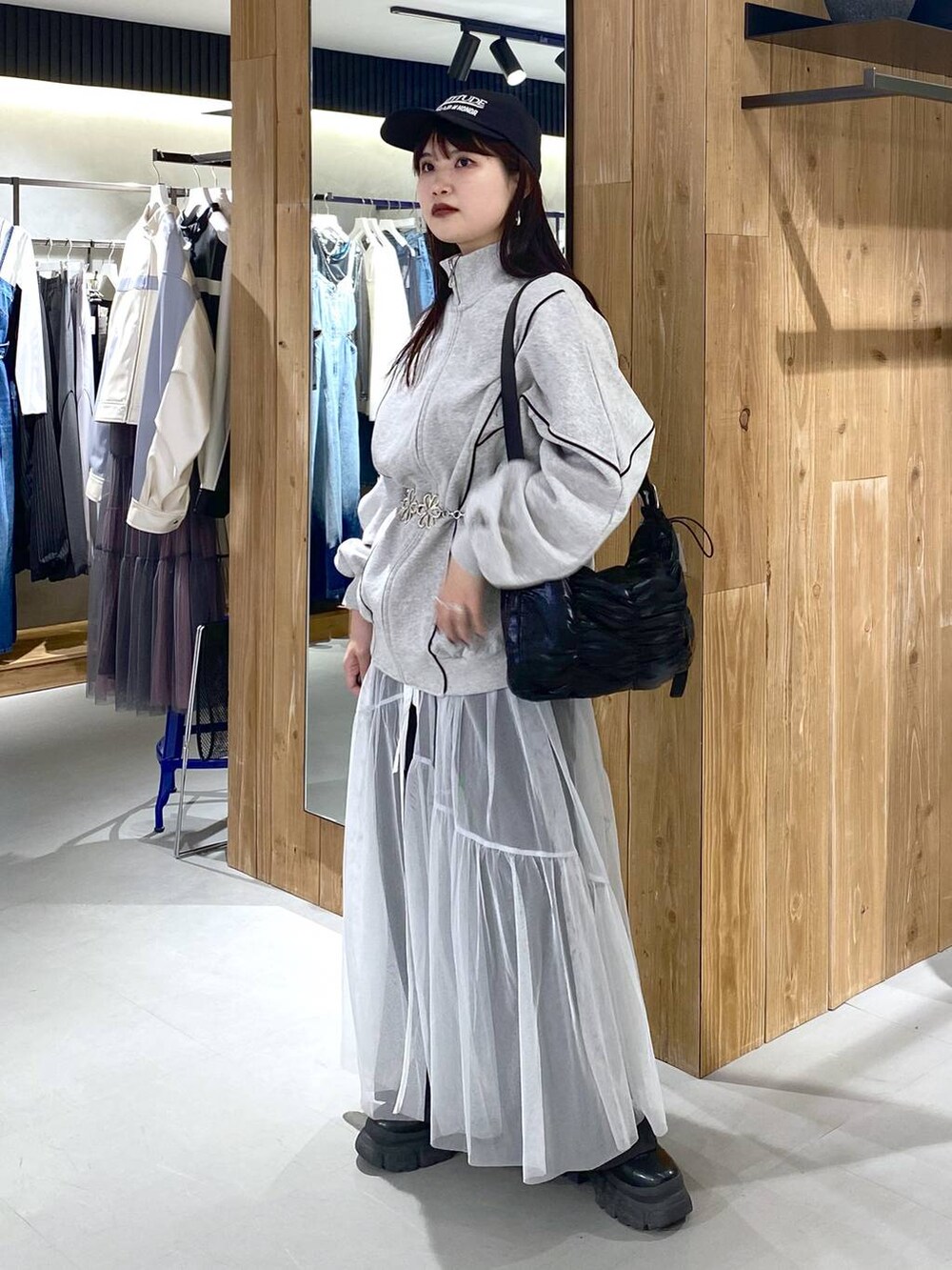 ブラック系のショルダーバッグ、グレー系のスウェット、ホワイト系のワンピースを着用したレディースの春コーディネートの6枚目の写真
