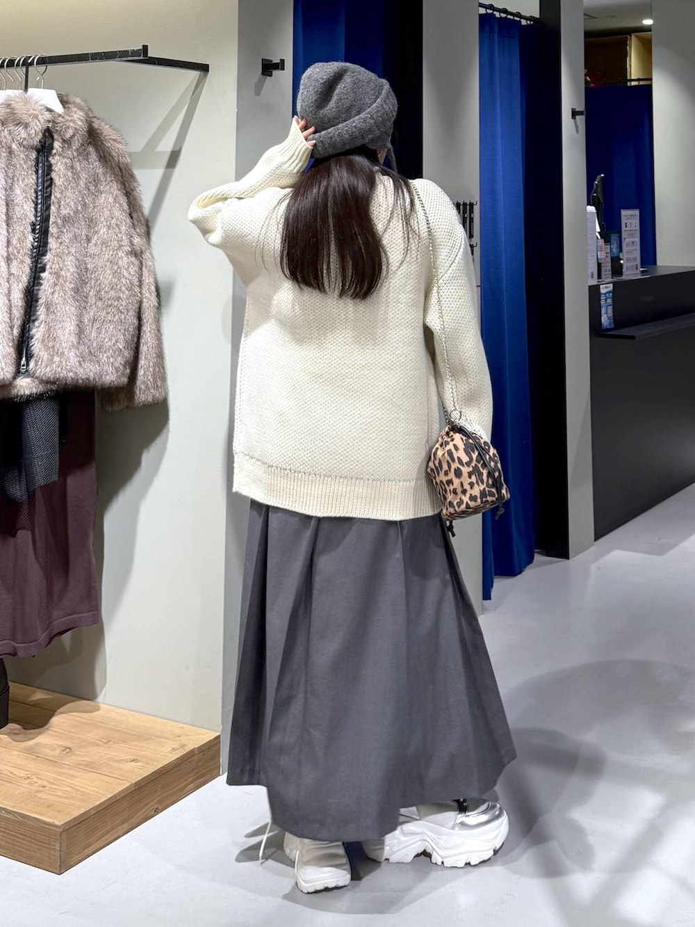 ホワイト系のブーツ、ホワイト系のニット/セーター、グレー系のスカートを着用したレディースの冬コーディネートの5枚目の写真