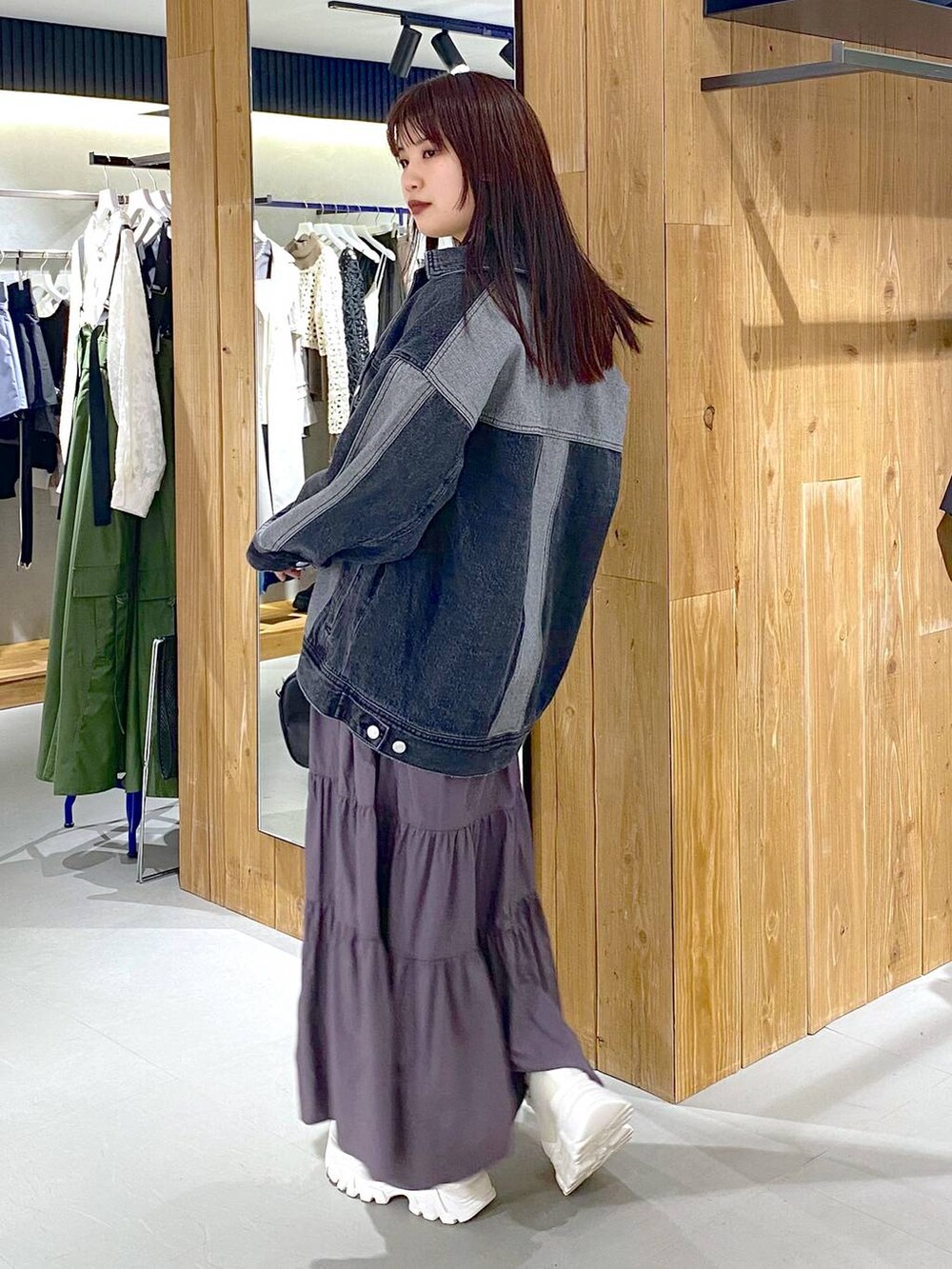 ブルー系のタンクトップ、ブラック系のデニムジャケット、ブラック系のボストンバッグを着用したレディースの春コーディネートの4枚目の写真