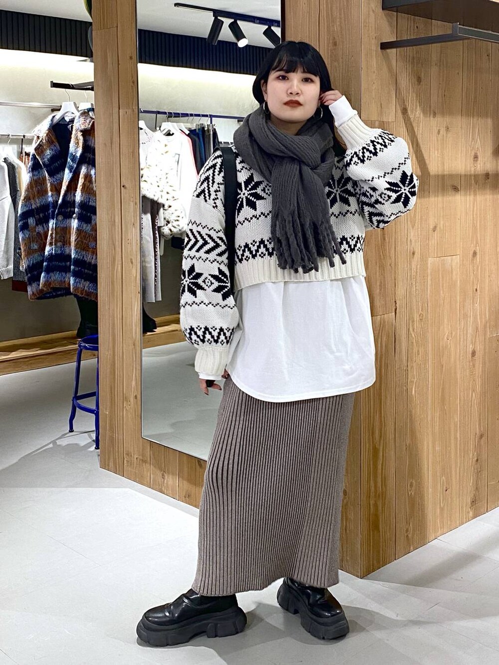 ブラック系のブーツ、ホワイト系のTシャツ/カットソー、ブラック系のショルダーバッグを着用したレディースの冬コーディネートの6枚目の写真