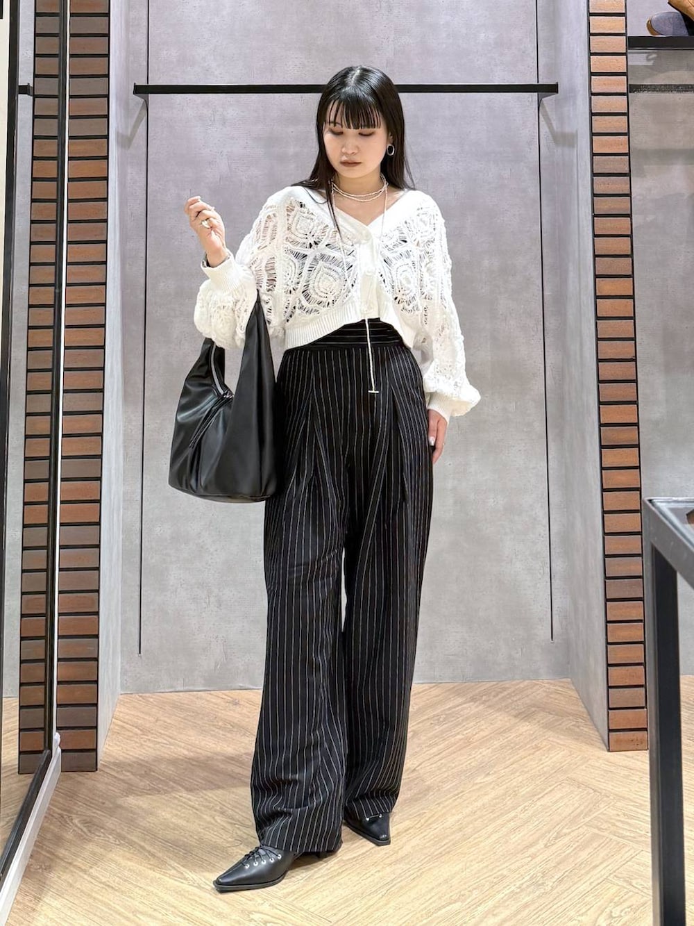 ブラック系のキャミソール、ホワイト系のカーディガン/ボレロ、ブラック系のトートバッグを着用したレディースの春コーディネートの2枚目の写真