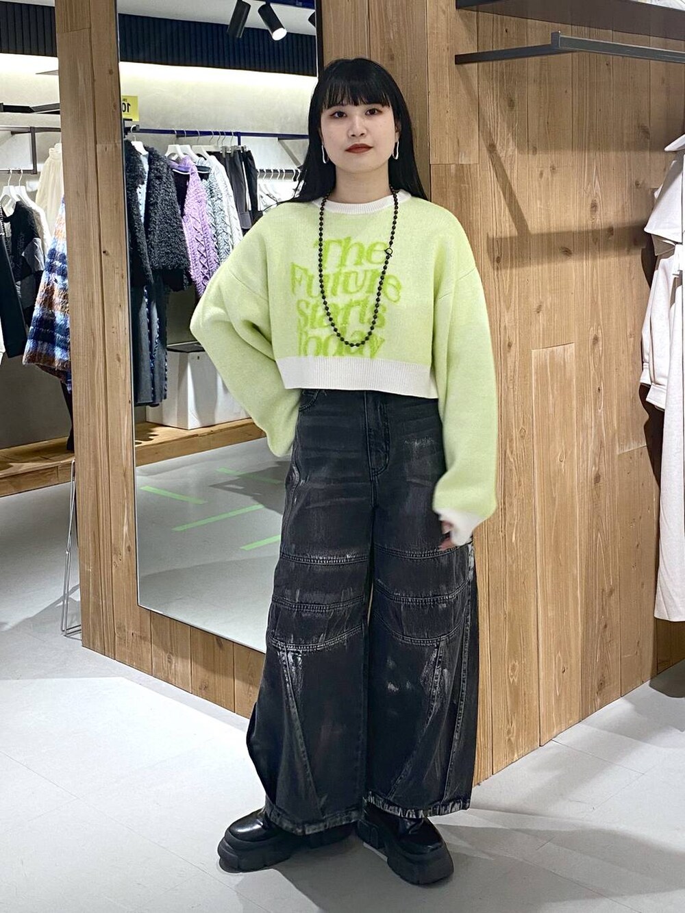 ブラック系のブーツ、ホワイト系のニット/セーター、ブラック系のショルダーバッグを着用したレディースの冬コーディネートの2枚目の写真