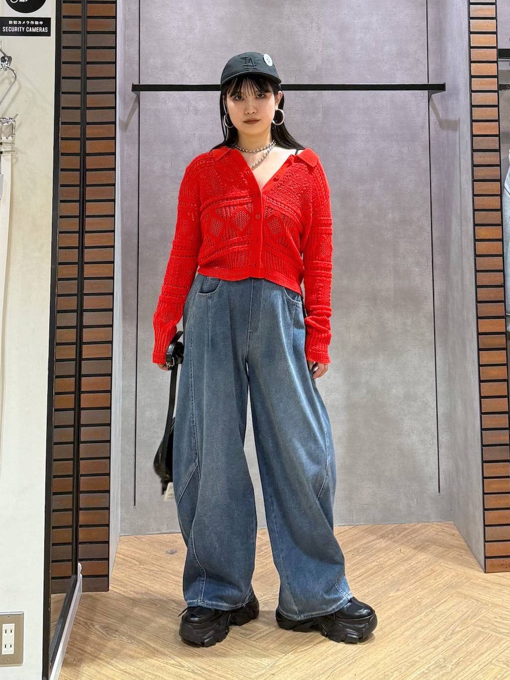 ブラック系のキャミソール、ブルー系のデニムパンツ、ブラック系のショルダーバッグを着用したレディースの春コーディネートの7枚目の写真