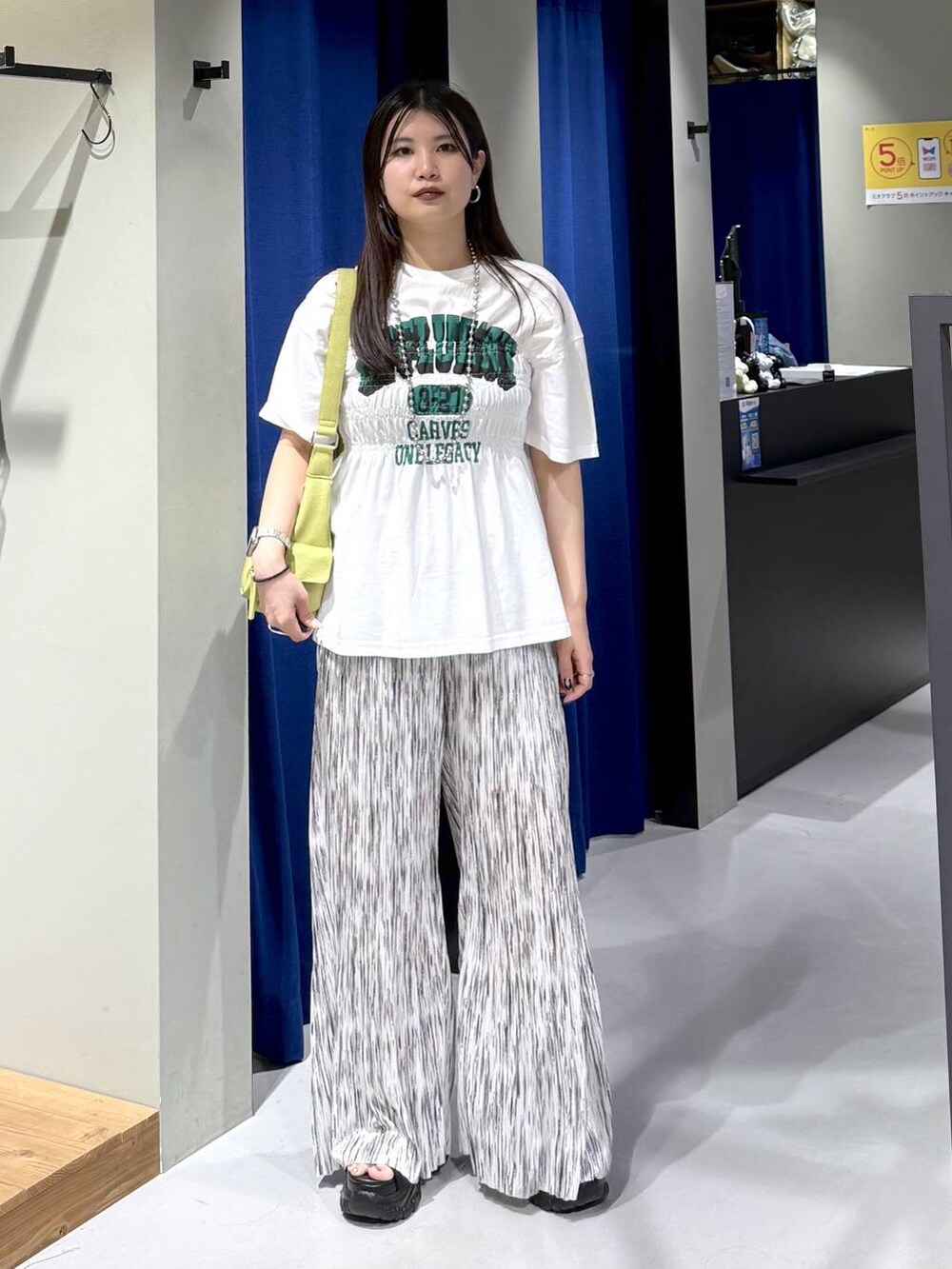 ブラック系のサンダル、グリーン系のショルダーバッグ、ホワイト系のその他パンツを着用したレディースの夏コーディネートの6枚目の写真