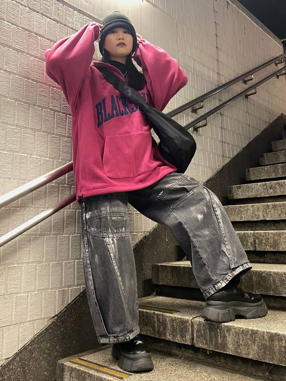 ブラック系のブーツ、ピンク系のその他トップス、ブラック系のデニムパンツを着用したレディースの冬コーディネートの3枚目の写真