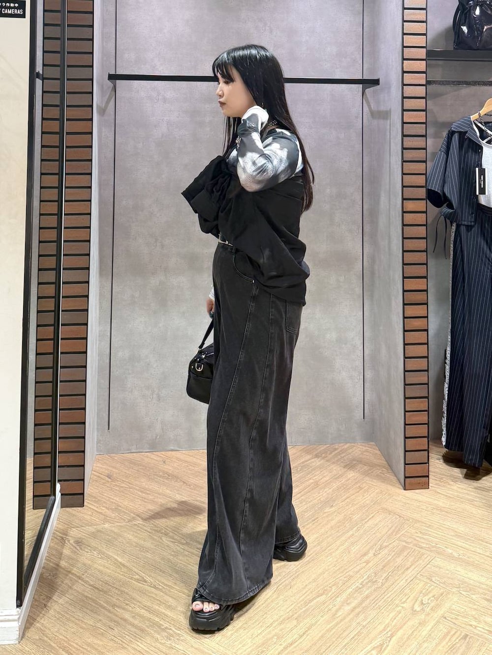 ブラック系のデニムパンツ、ブラック系のショルダーバッグ、グレー系のその他トップスを着用したレディースの夏コーディネートの3枚目の写真