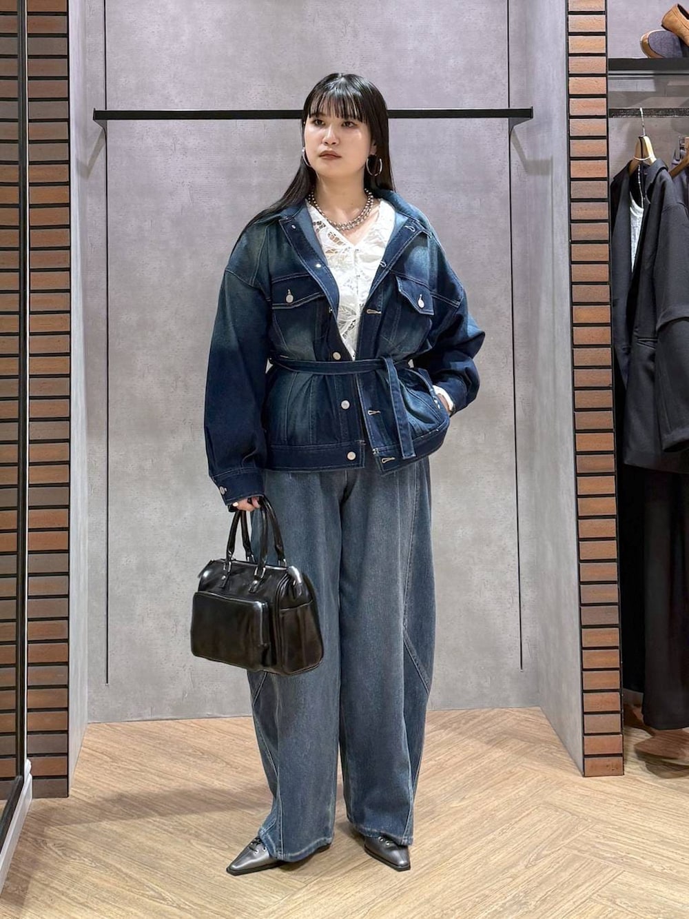 ブルー系のブルゾン、グレー系のショルダーバッグ、ホワイト系のタンクトップを着用したレディースの春コーディネートの2枚目の写真