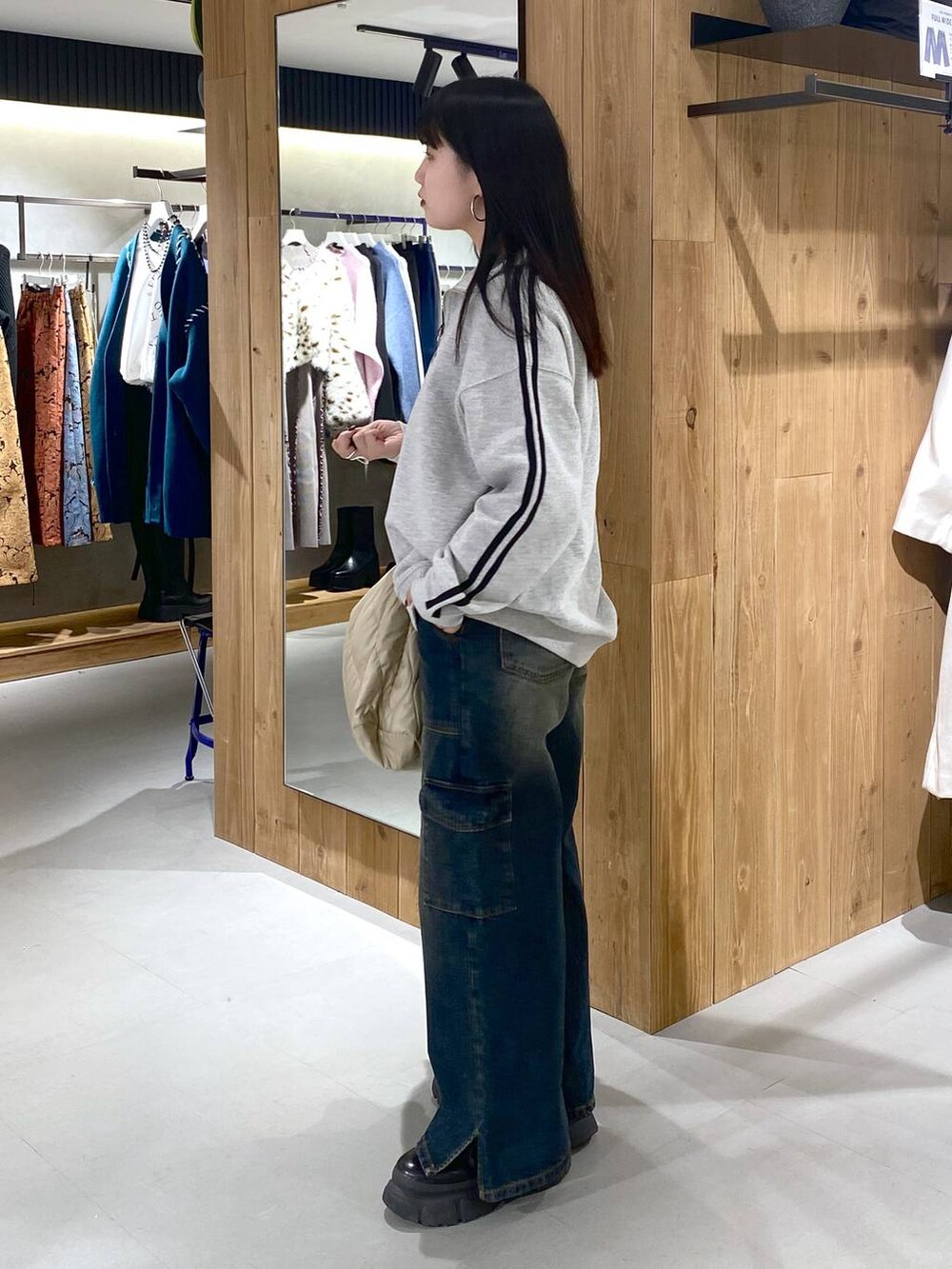 ブラック系のブーツ、グレー系のスウェット、ベージュ系のショルダーバッグを着用したレディースの冬コーディネートの2枚目の写真