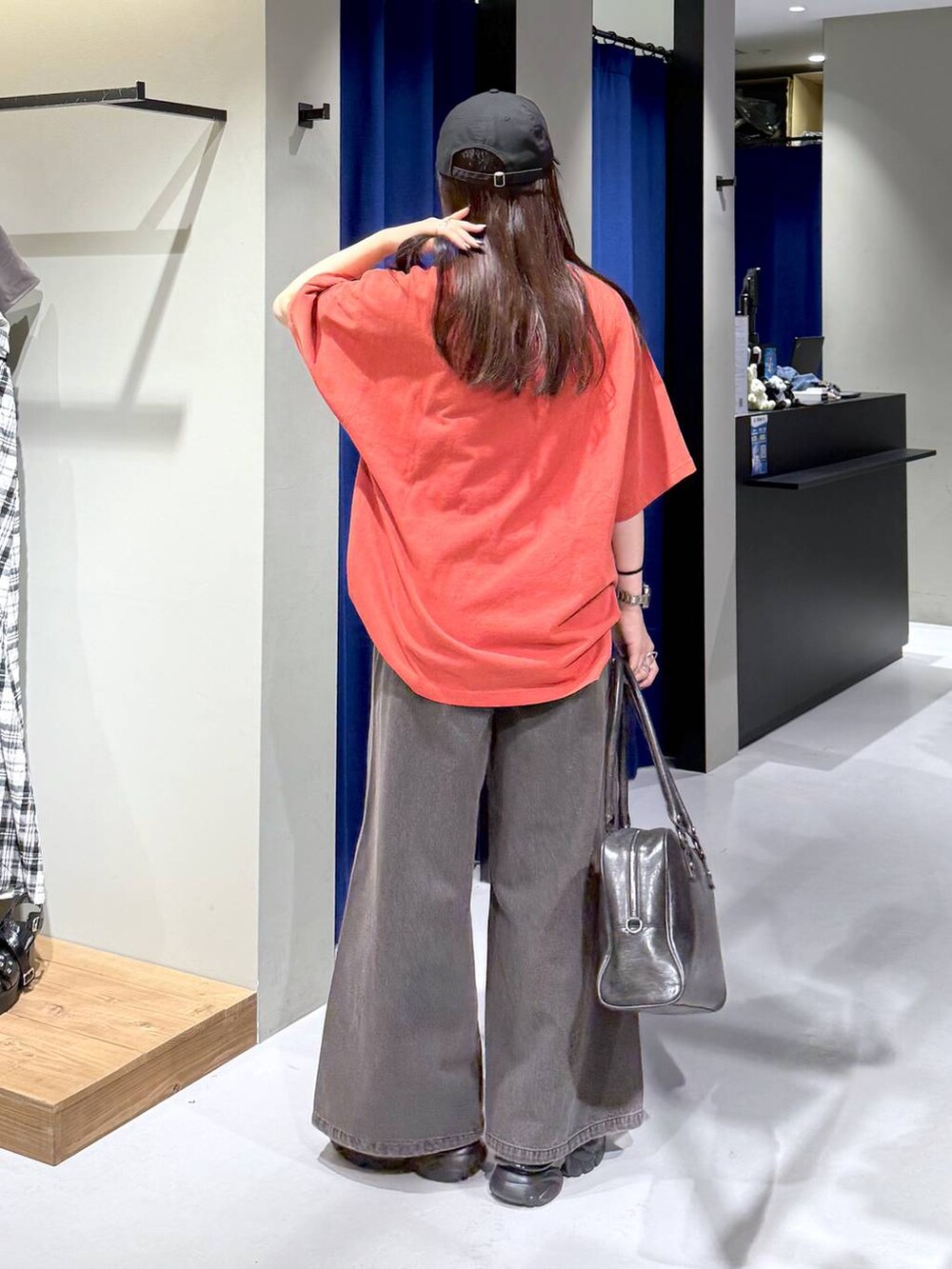 ブラック系のデニムパンツ、ブラック系のボストンバッグ、グレー系のサンダルを着用したレディースの夏コーディネートの2枚目の写真