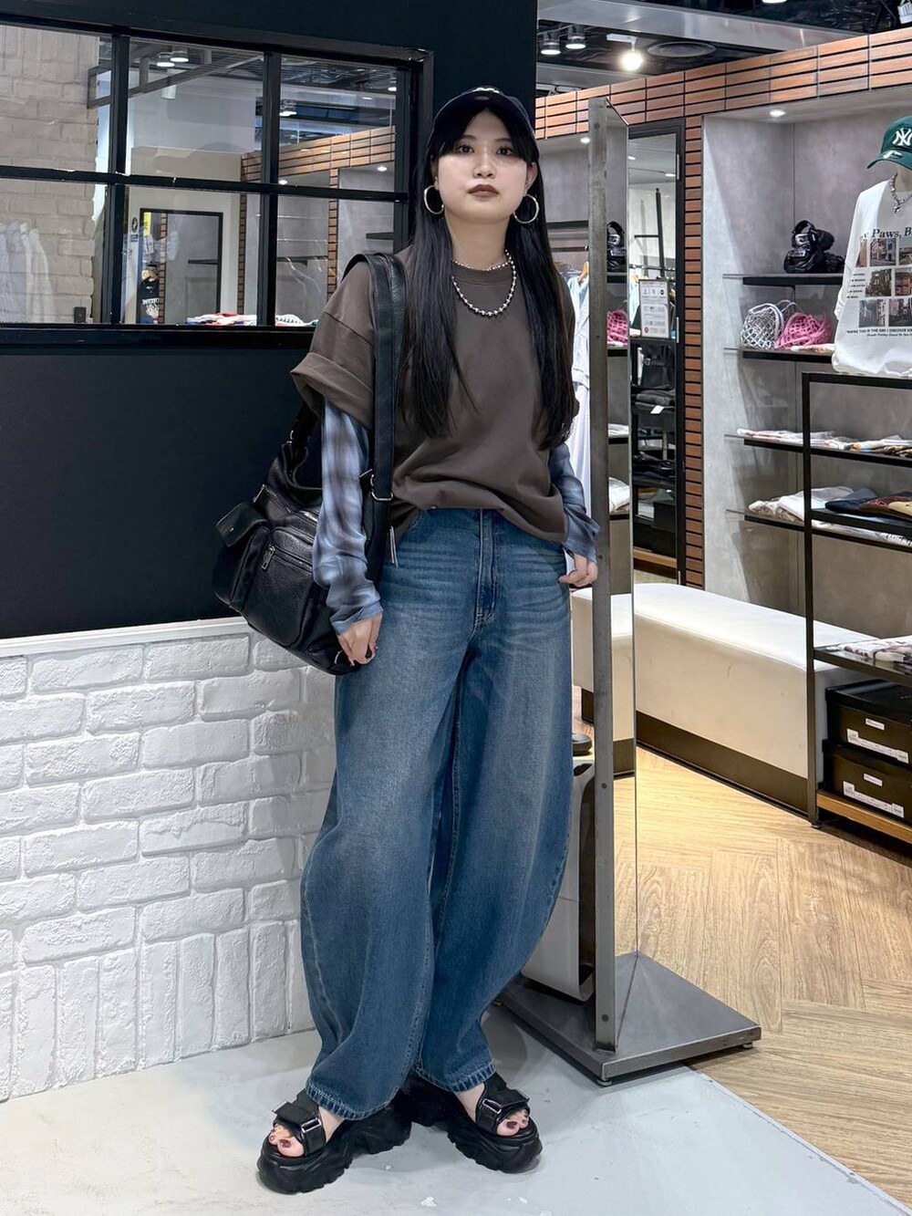 ブラウン系のショルダーバッグ、ブラック系のサンダル、ブラウン系のTシャツ/カットソーを着用したレディースの夏コーディネートの4枚目の写真