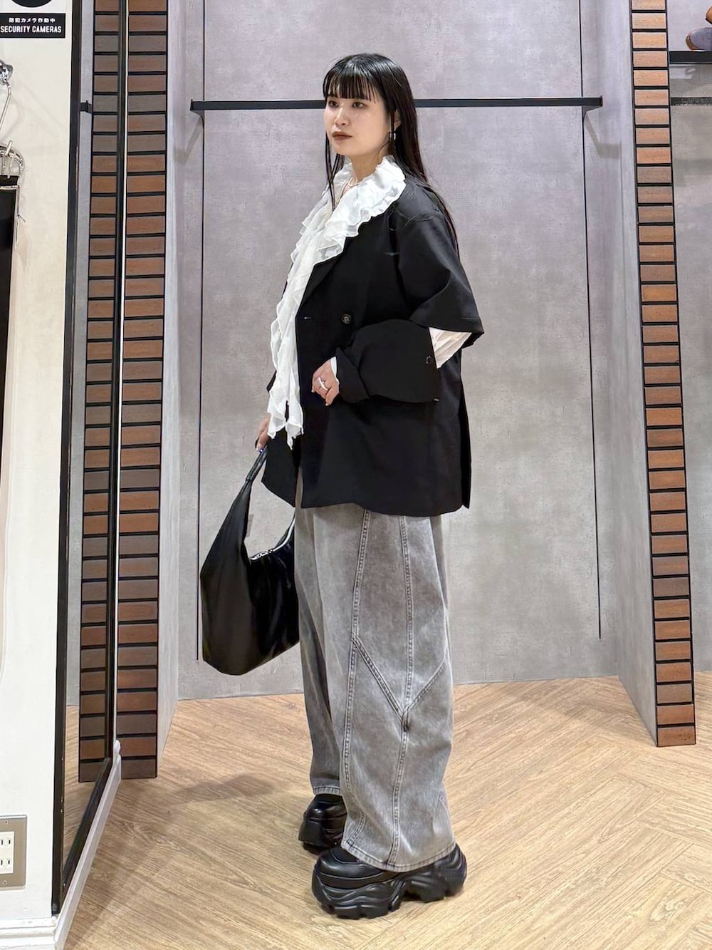 ブラック系のブーツ、ブラック系のキャミソール、ブラック系のデニムパンツを着用したレディースの春コーディネートの2枚目の写真