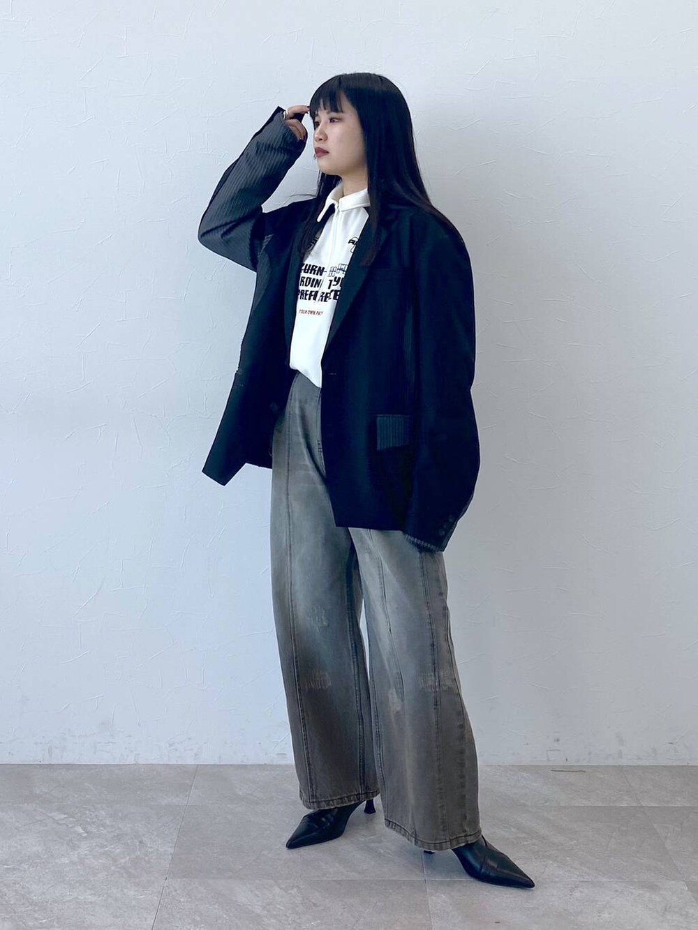 ブラック系のテーラードジャケット、ホワイト系のポロシャツを着用したレディースの冬コーディネートの6枚目の写真