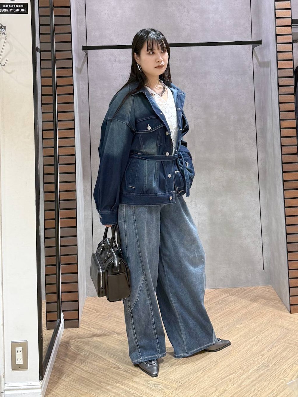 ブルー系のブルゾン、グレー系のショルダーバッグ、ホワイト系のタンクトップを着用したレディースの春コーディネートの5枚目の写真