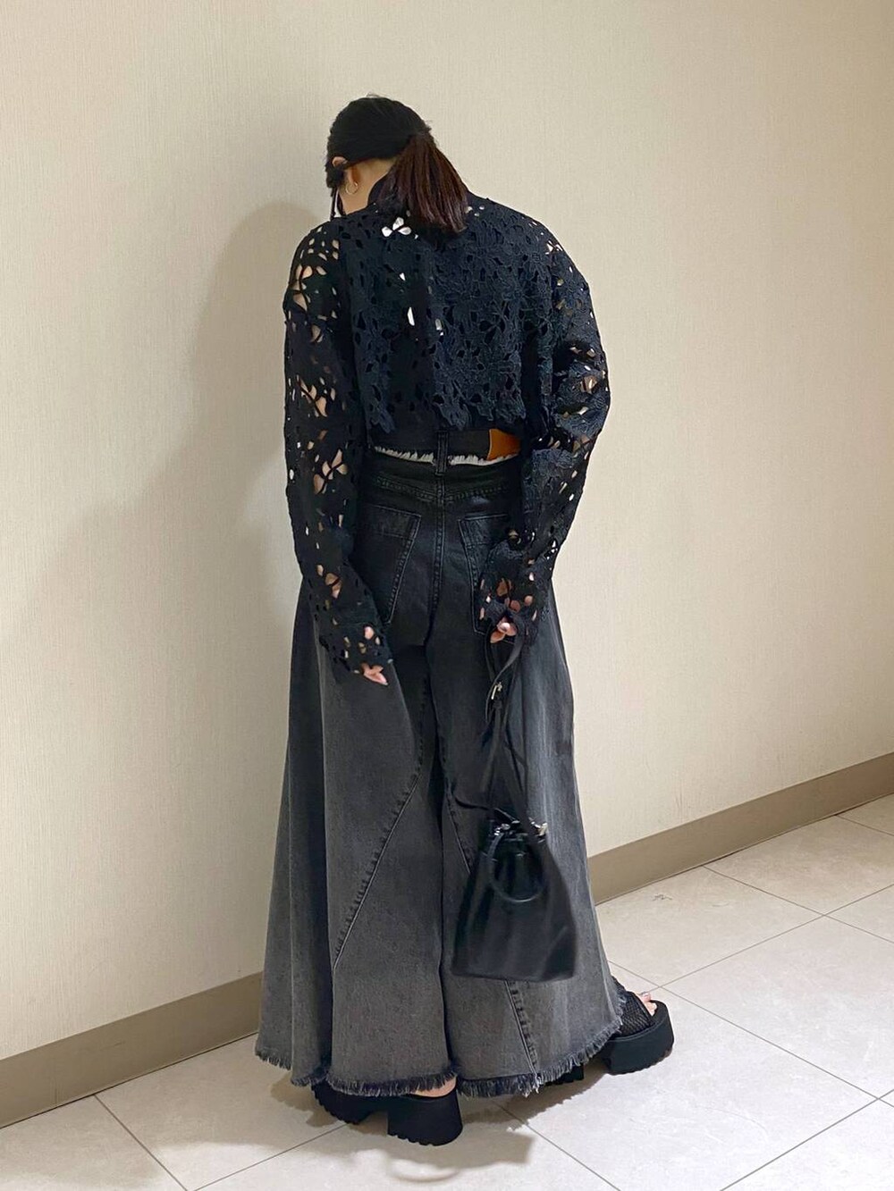 ブラック系のタンクトップ、ブラック系のショルダーバッグ、ブラック系のデニムパンツを着用したレディースの夏コーディネートの2枚目の写真