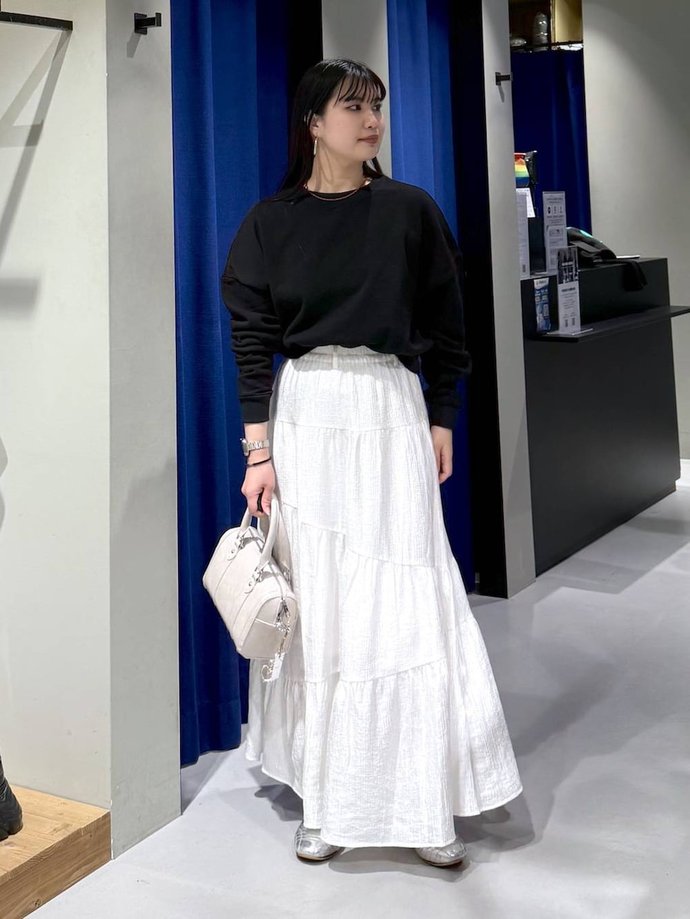 ブラック系のスウェット、ブラウン系のボストンバッグ、ブルー系のブルゾンを着用したレディースの春コーディネートの2枚目の写真