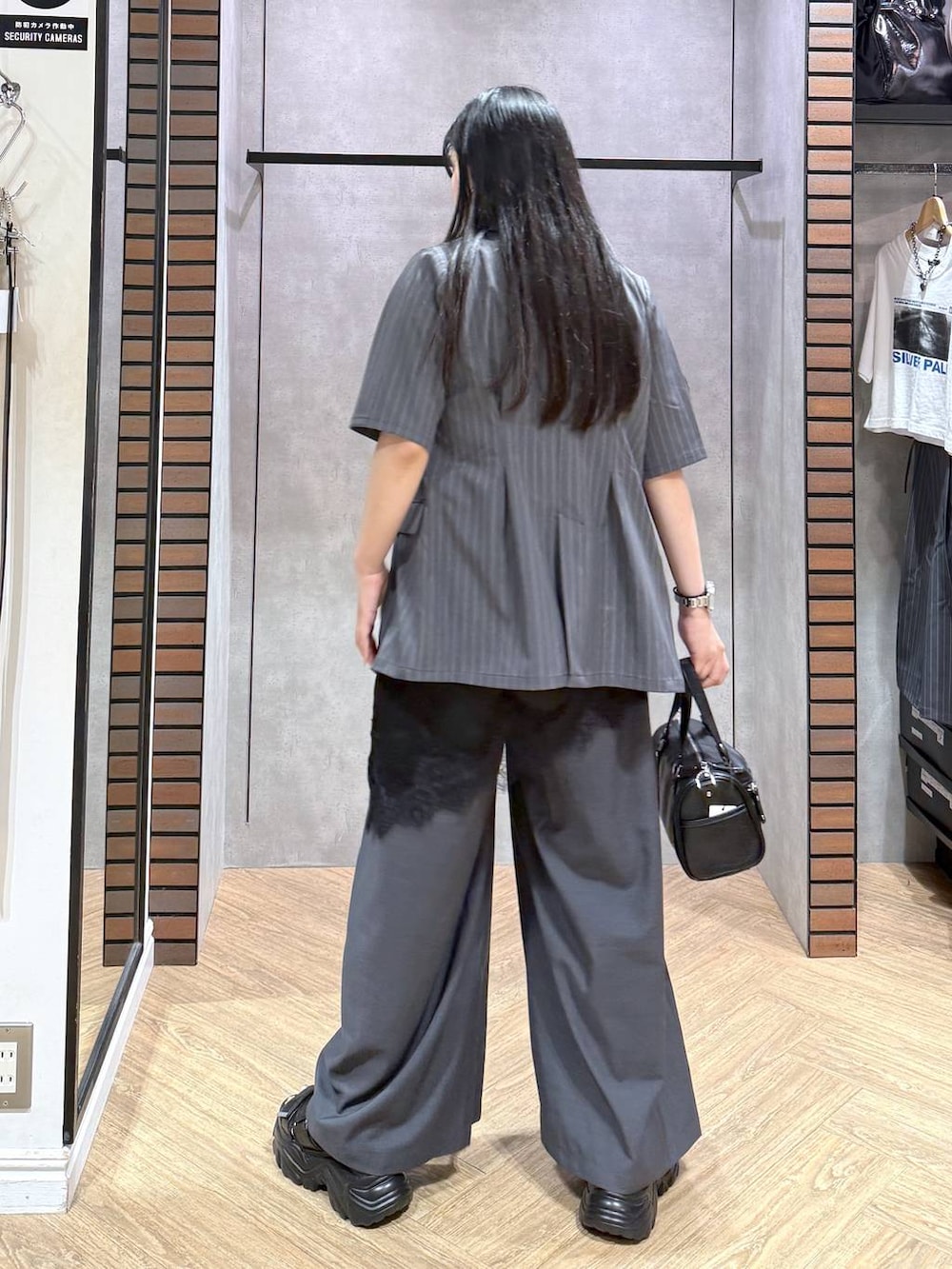 ブラック系のデニムパンツ、ブラック系のショルダーバッグ、ブラック系のチュニックを着用したレディースの夏コーディネートの6枚目の写真
