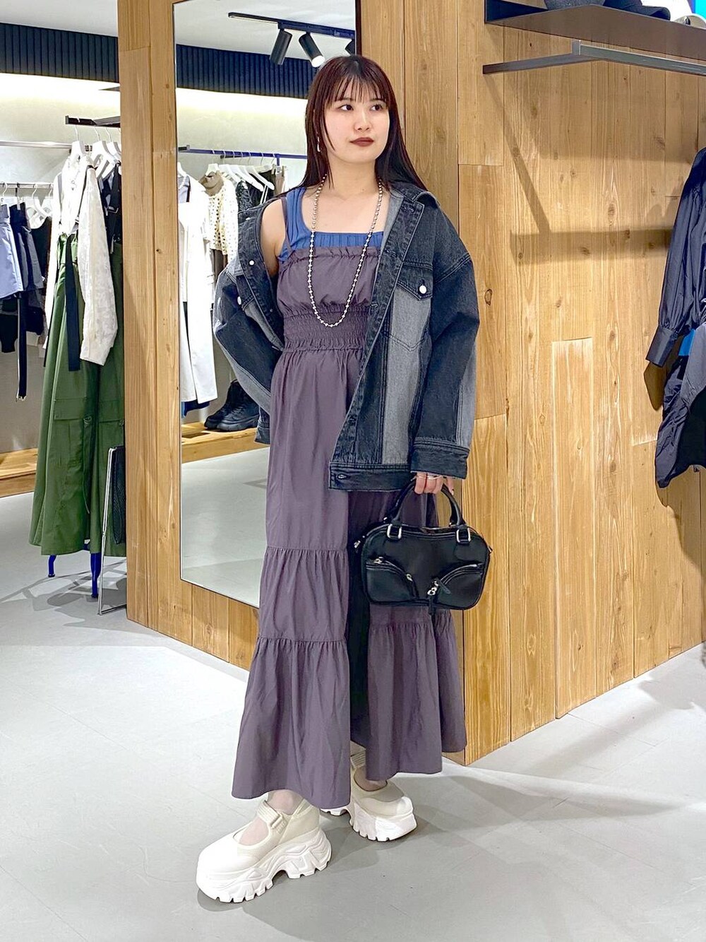 ブルー系のタンクトップ、ブラック系のデニムジャケット、ブラック系のボストンバッグを着用したレディースの春コーディネートの5枚目の写真