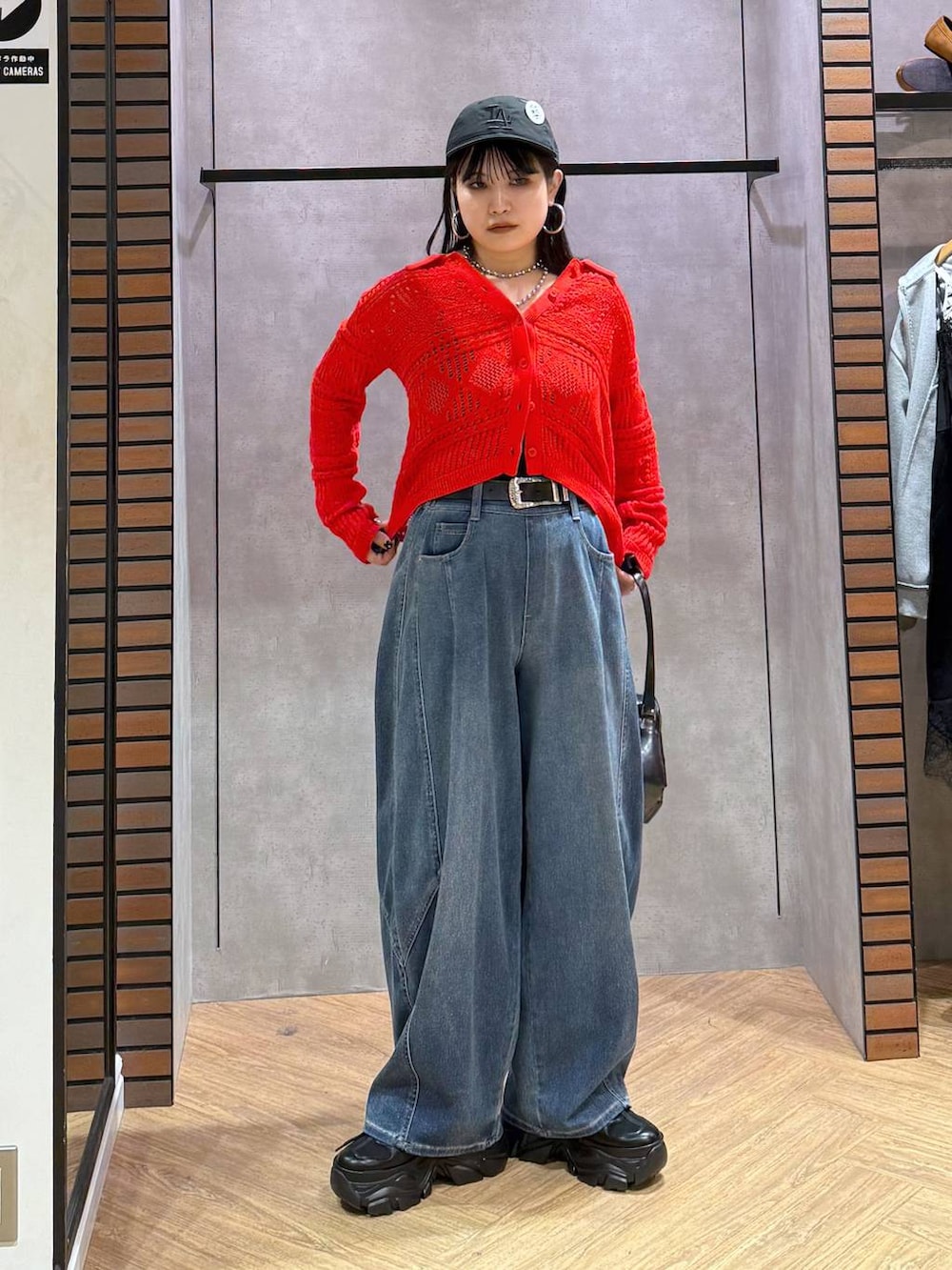 ブラック系のキャミソール、ブルー系のデニムパンツ、ブラック系のショルダーバッグを着用したレディースの春コーディネートの5枚目の写真