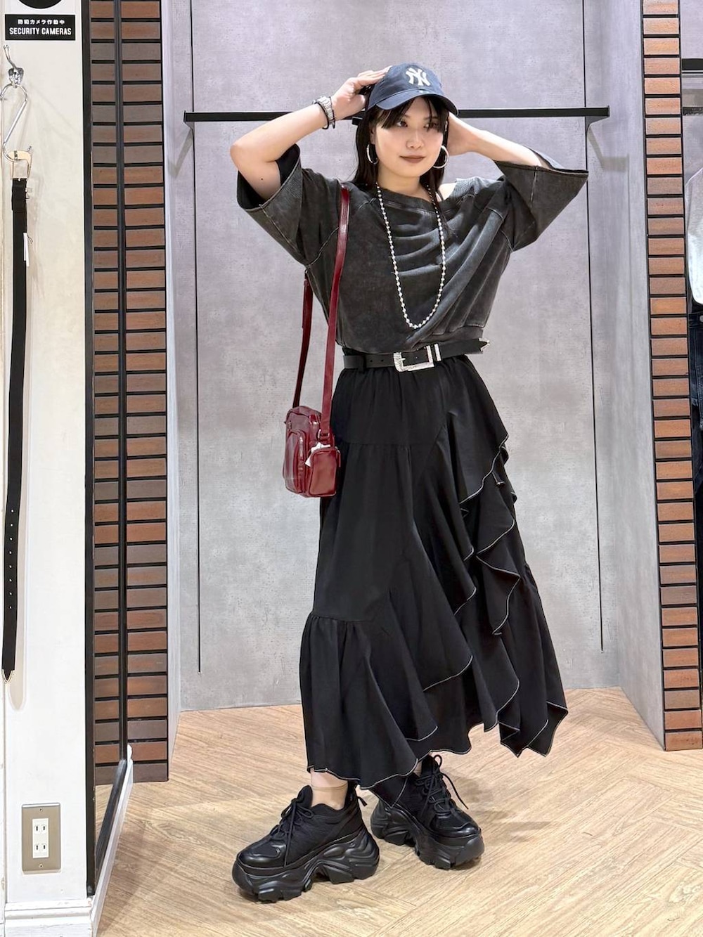 ブラック系のTシャツ/カットソー、ブラック系のスニーカー、ブラック系のキャミソールを着用したレディースの夏コーディネートの4枚目の写真