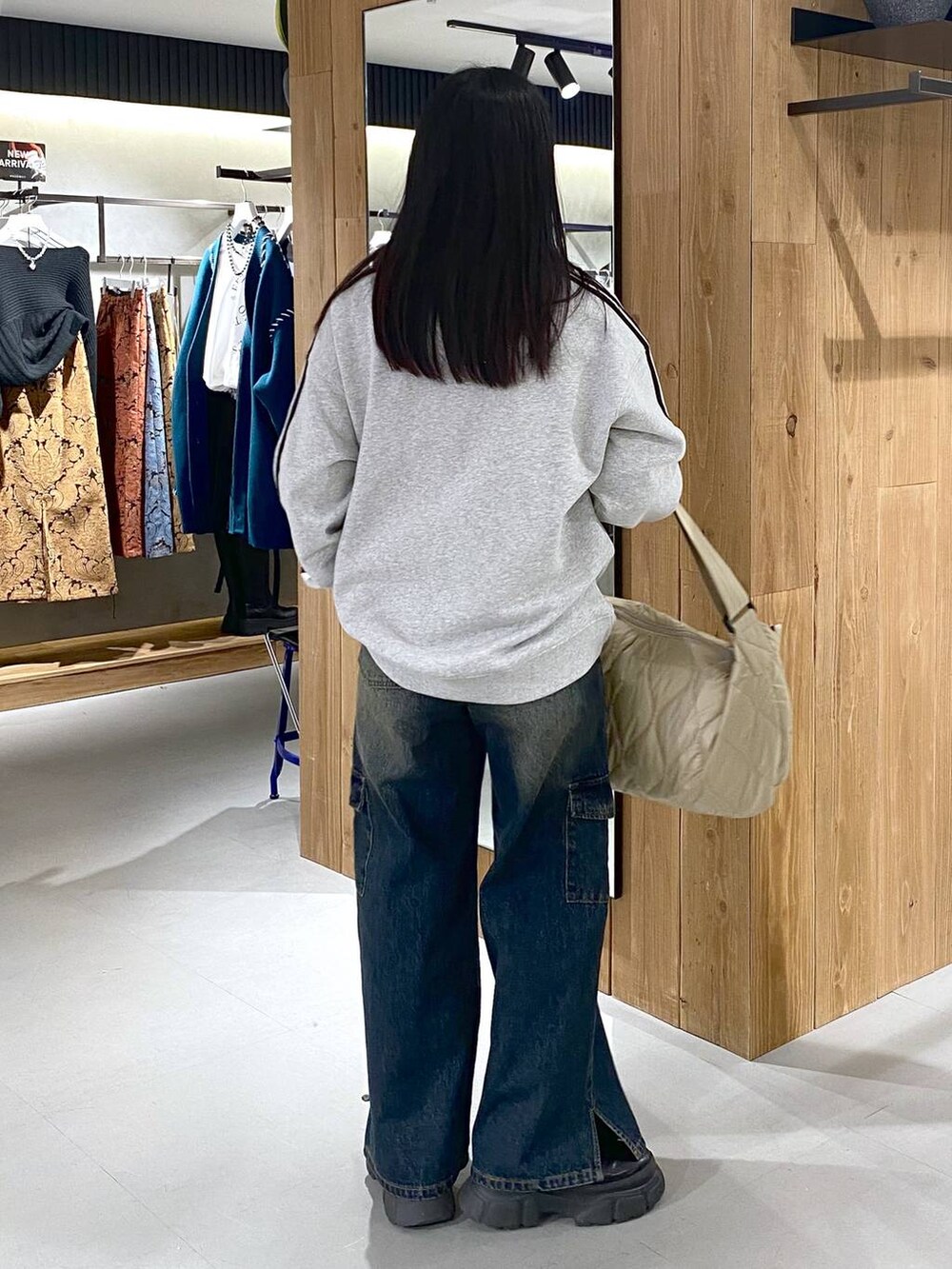 ブラック系のブーツ、グレー系のスウェット、ベージュ系のショルダーバッグを着用したレディースの冬コーディネートの4枚目の写真