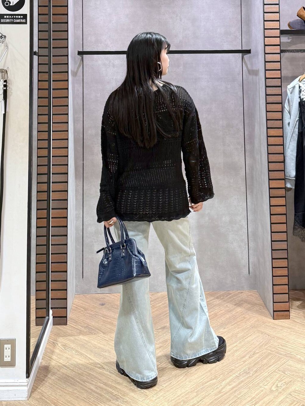 ブラック系のスニーカー、ブラック系のキャミソール、ブルー系のデニムパンツを着用したレディースの春コーディネートの2枚目の写真