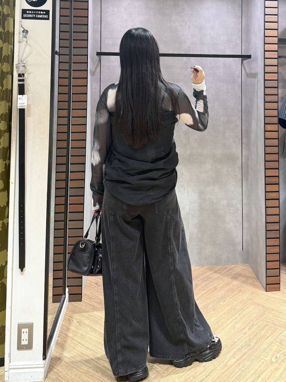 ブラック系のデニムパンツ、ブラック系のショルダーバッグ、グレー系のその他トップスを着用したレディースの夏コーディネートの2枚目の写真