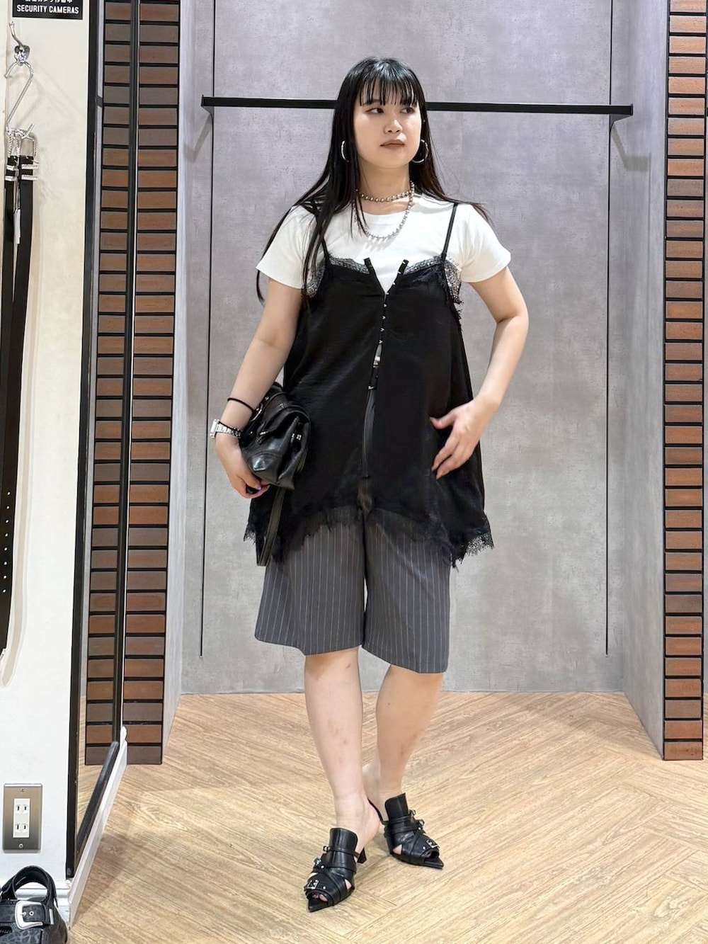 ブラック系のサンダル、ホワイト系のTシャツ/カットソー、ブラック系のキャミソールを着用したレディースの夏コーディネートの3枚目の写真