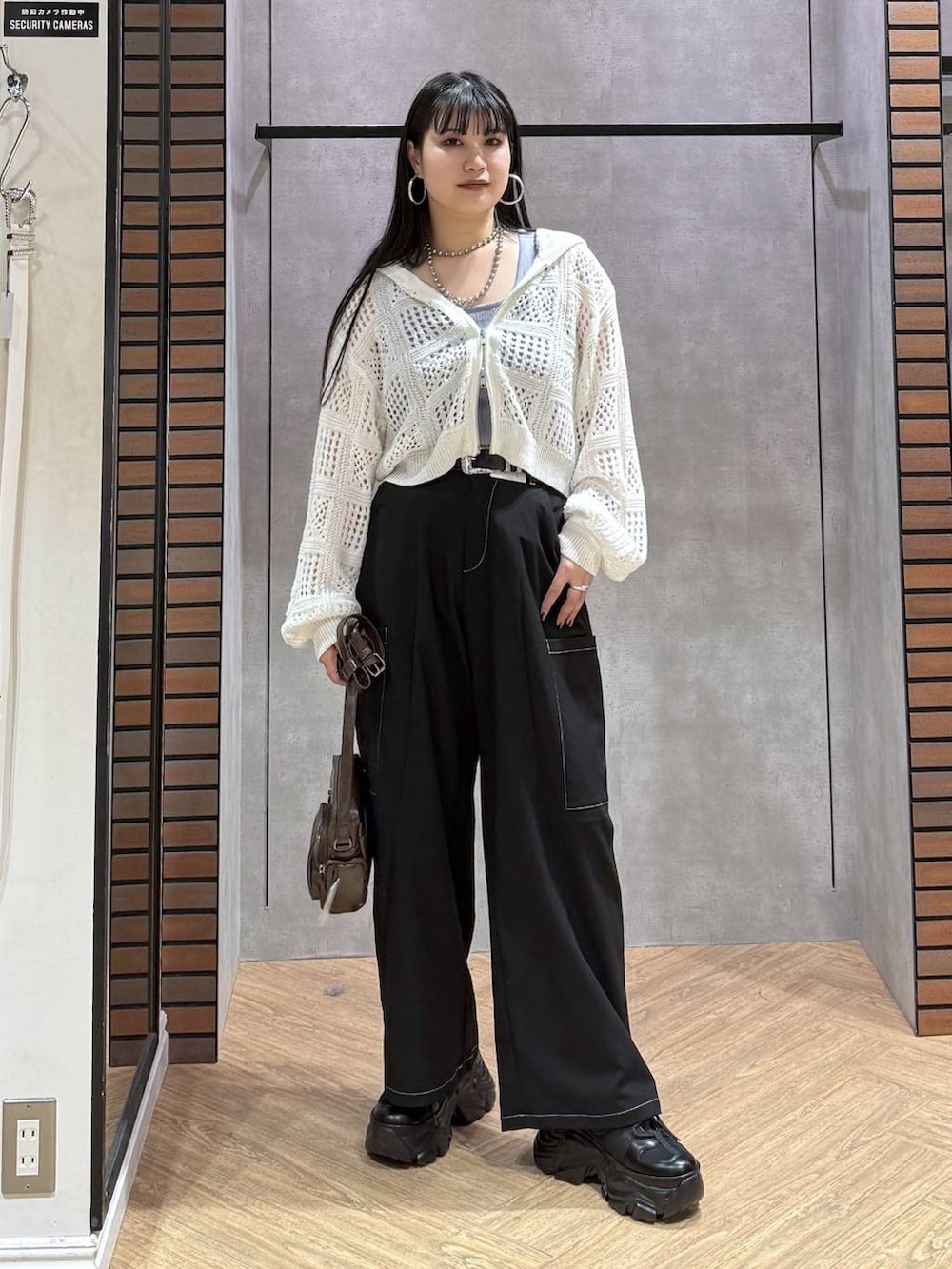 ブラック系のスニーカー、ブラウン系のショルダーバッグ、ブルー系のタンクトップを着用したレディースの春コーディネートの7枚目の写真