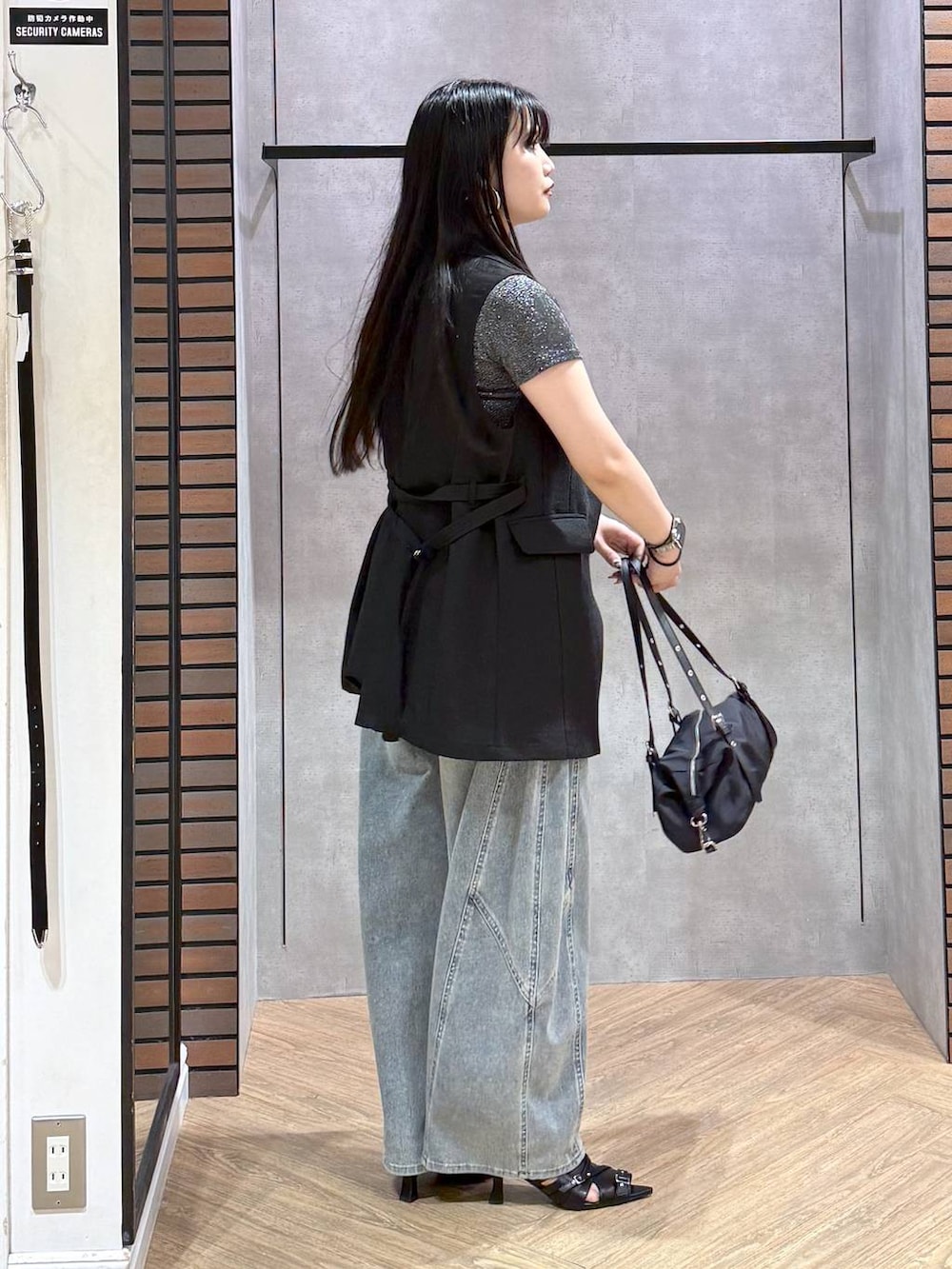 ブルー系のデニムパンツ、ブラック系のサンダル、ブラック系のテーラードジャケットを着用したレディースの夏コーディネートの6枚目の写真