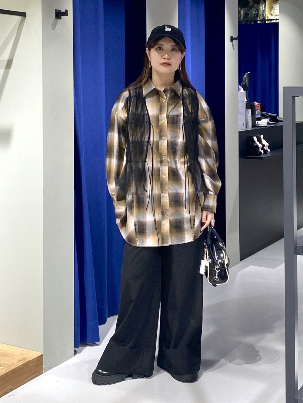 ブラック系のショルダーバッグ、ブラック系のその他パンツ、ブラック系のブーツを着用したレディースの夏コーディネートの2枚目の写真