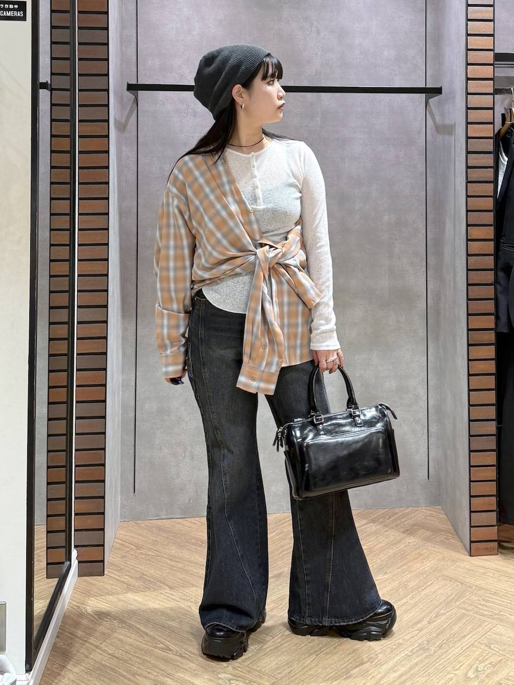 ブラック系のスニーカー、ブルー系のデニムパンツ、ブラック系のショルダーバッグを着用したレディースの春コーディネートの2枚目の写真