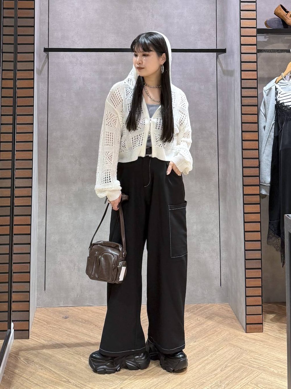 ブラック系のスニーカー、ブラウン系のショルダーバッグ、ブルー系のタンクトップを着用したレディースの春コーディネートの5枚目の写真