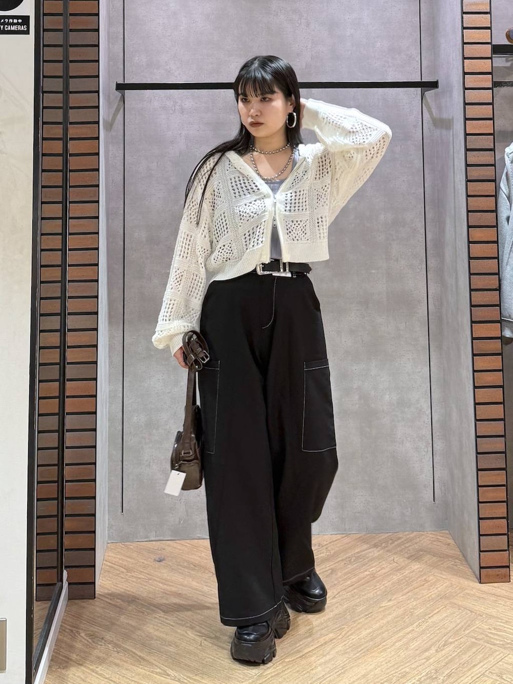 ブラック系のスニーカー、ブラウン系のショルダーバッグ、ブルー系のタンクトップを着用したレディースの春コーディネートの4枚目の写真