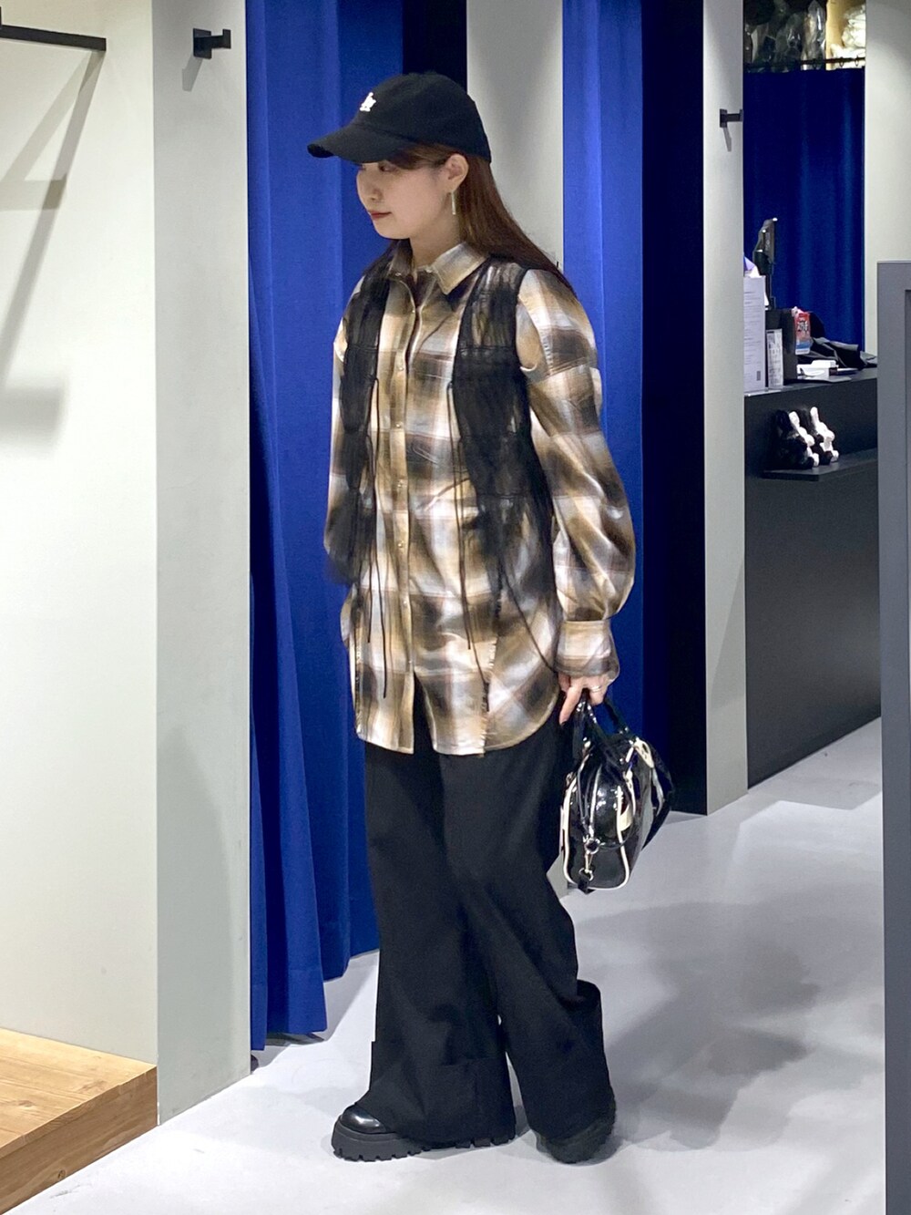 ブラック系のショルダーバッグ、ブラック系のその他パンツ、ブラック系のブーツを着用したレディースの夏コーディネートの4枚目の写真